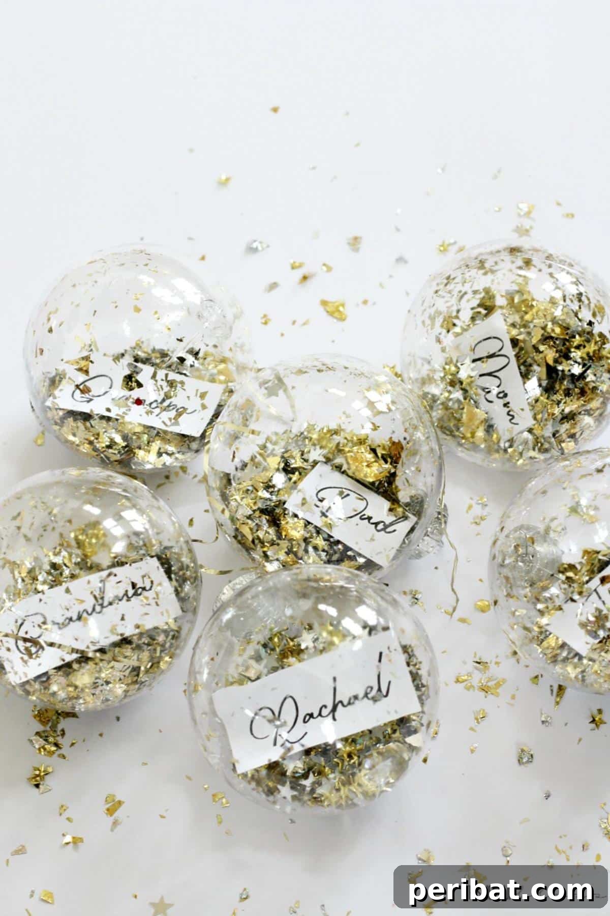 Dollar Store Ornament Place Cards. Features festive ornaments, personalized with names, used as place cards, offering a budget-friendly and creative solution for holiday tables.