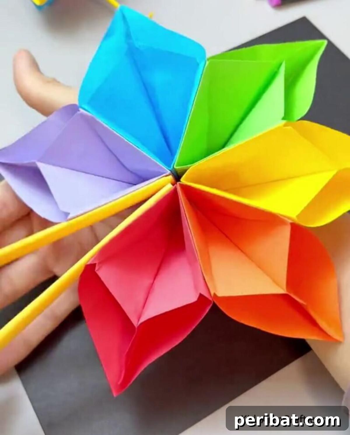 24 Creative DIY Paper Fan Projects 10 A vibrant DIY hand fan made with colorful paper, suitable for kids' craft projects, offering both decorative and functional uses.