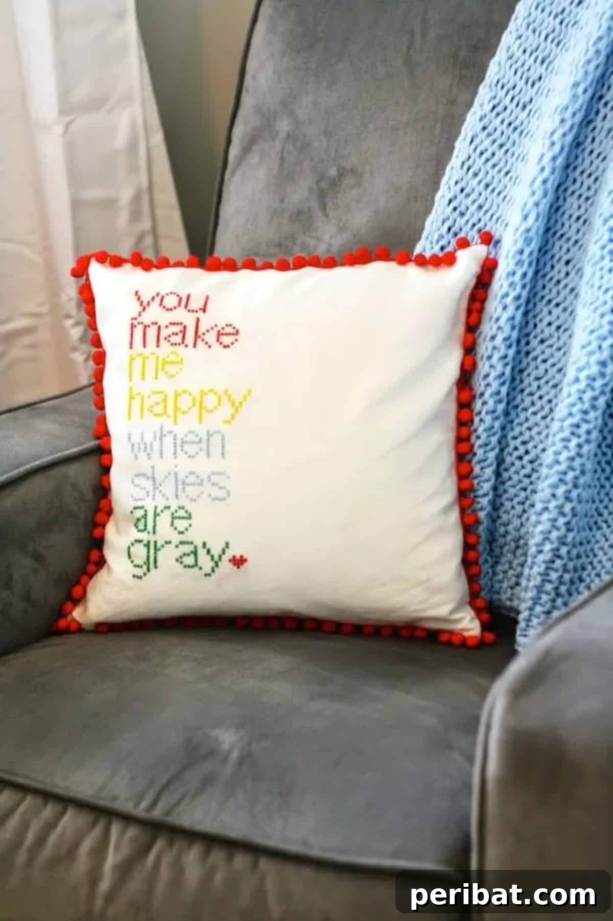 47 Inspiring DIY Throw Pillow Designs 13 A beautiful DIY cross-stitch pillow adorned with playful pom-pom trim.