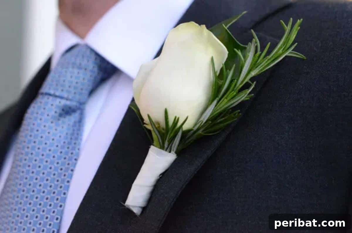 Craft Your Dream Wedding: 20 DIY Accessory Ideas 11 A rustic DIY boutonniere featuring a white rose, sprigs of rosemary and holly, tied with twine, perfect for a natural wedding theme.