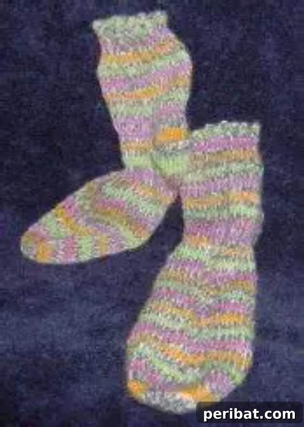 29 Inspiring Circular Knitting Designs 12 A pair of beautifully knitted Mock Cable Socks with Circular Needles, featuring a detailed mock cable stitch pattern in a soft, cozy yarn, highlighting intricate texture.