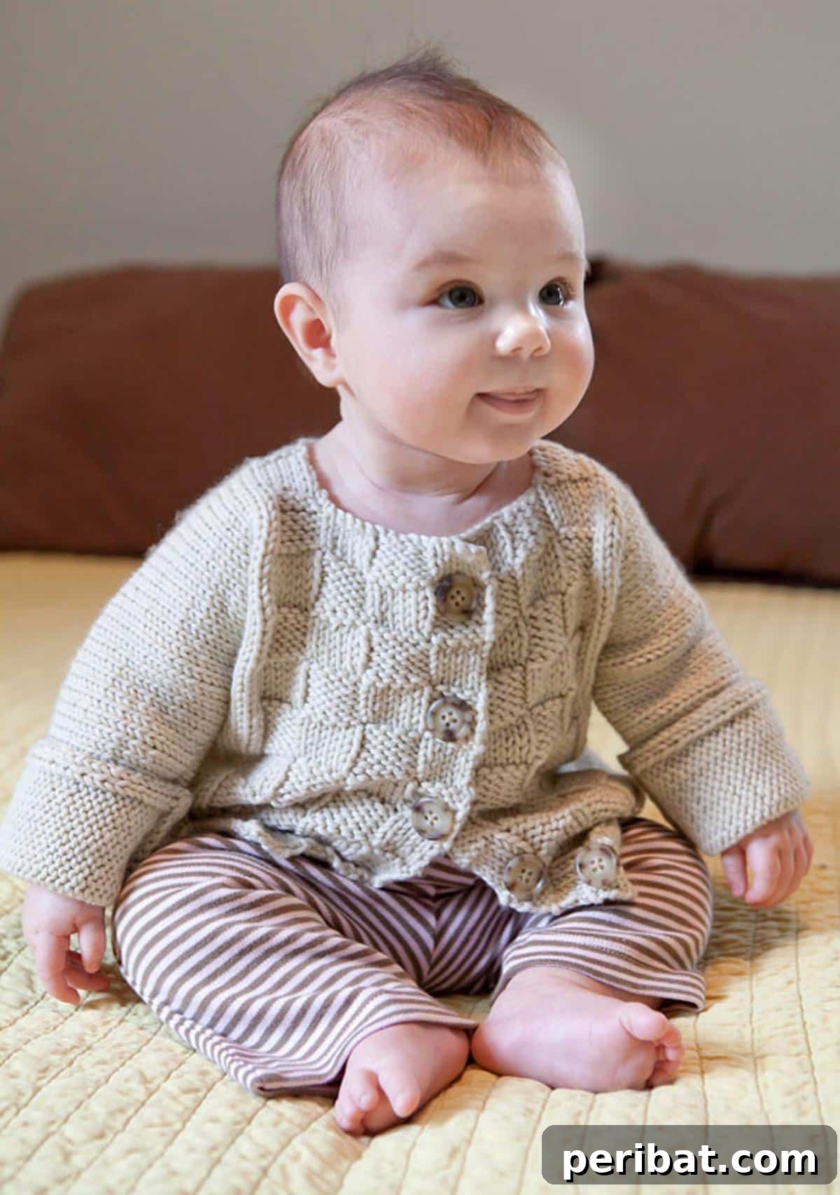 29 Inspiring Circular Knitting Designs 5 A charming close-up of the Baby Burnett cardigan, a delicate knitted garment for babies, featuring subtle texture and a classic design, perfect as a cherished gift.