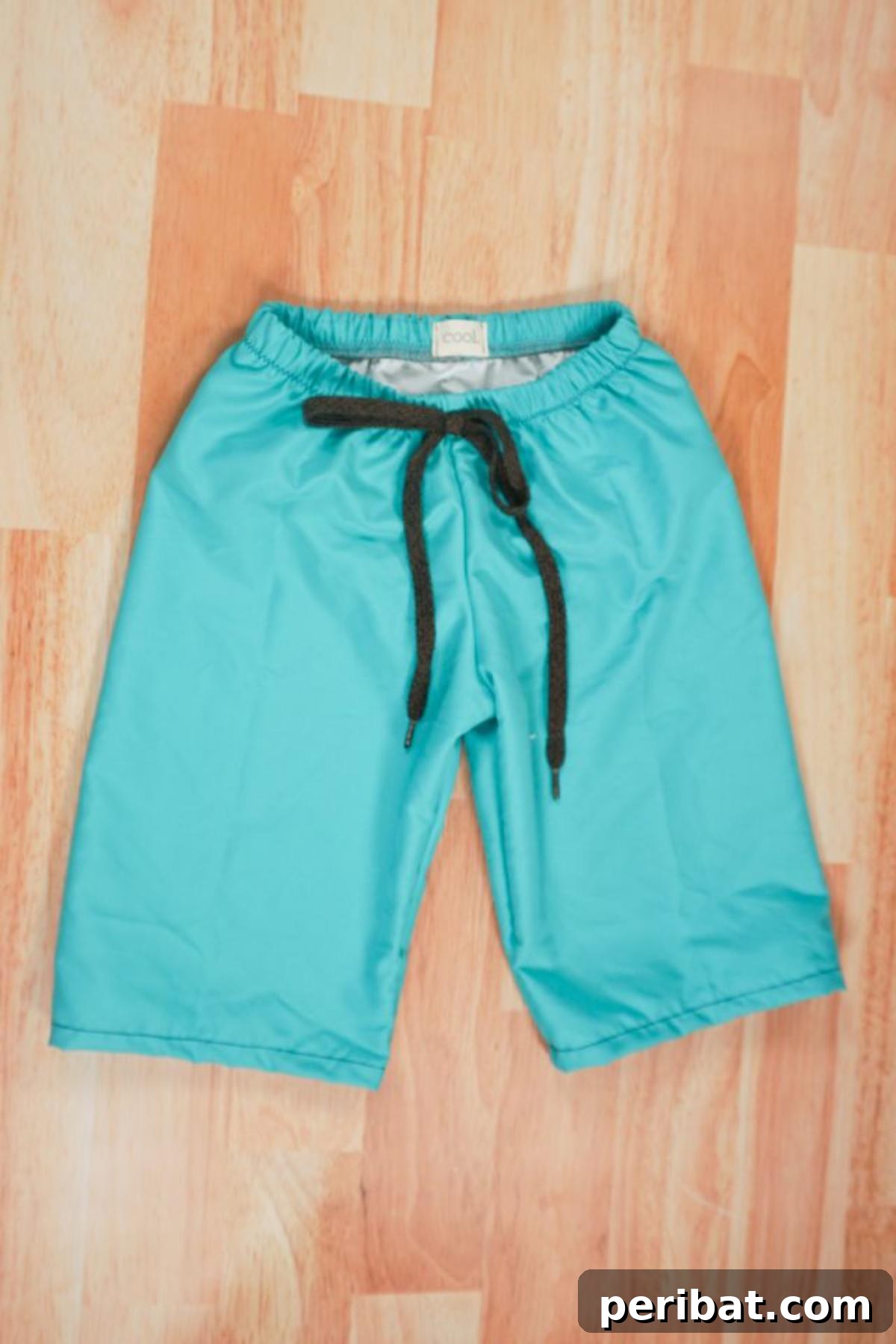 Gender-neutral swim trunks with an adjustable drawstring waist and elastic band for a comfortable and secure fit.