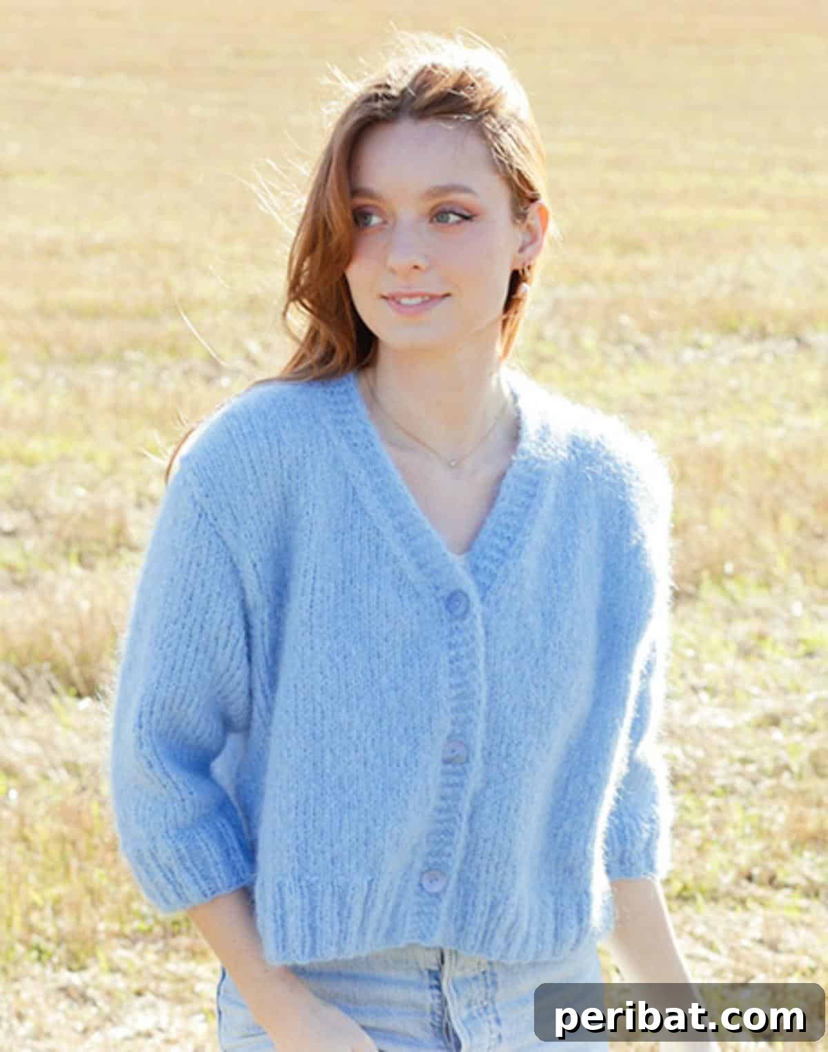 A beautifully crafted Painted Sky Cardigan in a serene light blue, featuring a V-neckline and three-quarter sleeves.