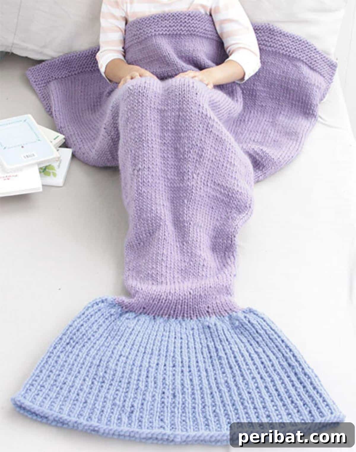 Cute Mermaid Blanket, a knitted pattern featuring vibrant purple and light blue yarn.