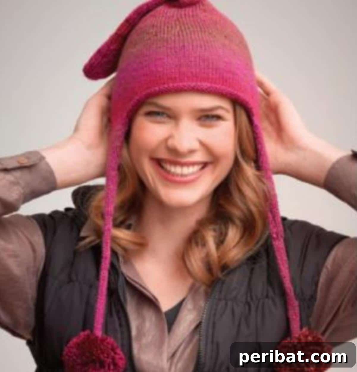 32 Cozy Ear Flap Hat Knitting Designs 22 An endearing knitted ear flap hat with dangling tassels, pompoms, and a cute decorative flap on top.