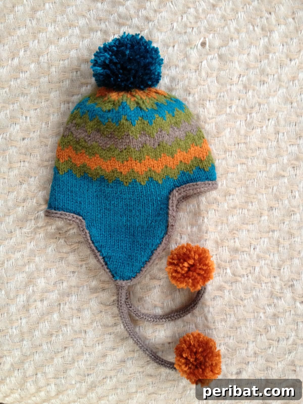 32 Cozy Ear Flap Hat Knitting Designs 6 A vibrant Adelisa earflap hat featuring stunning Chevron colorwork in multiple hues.