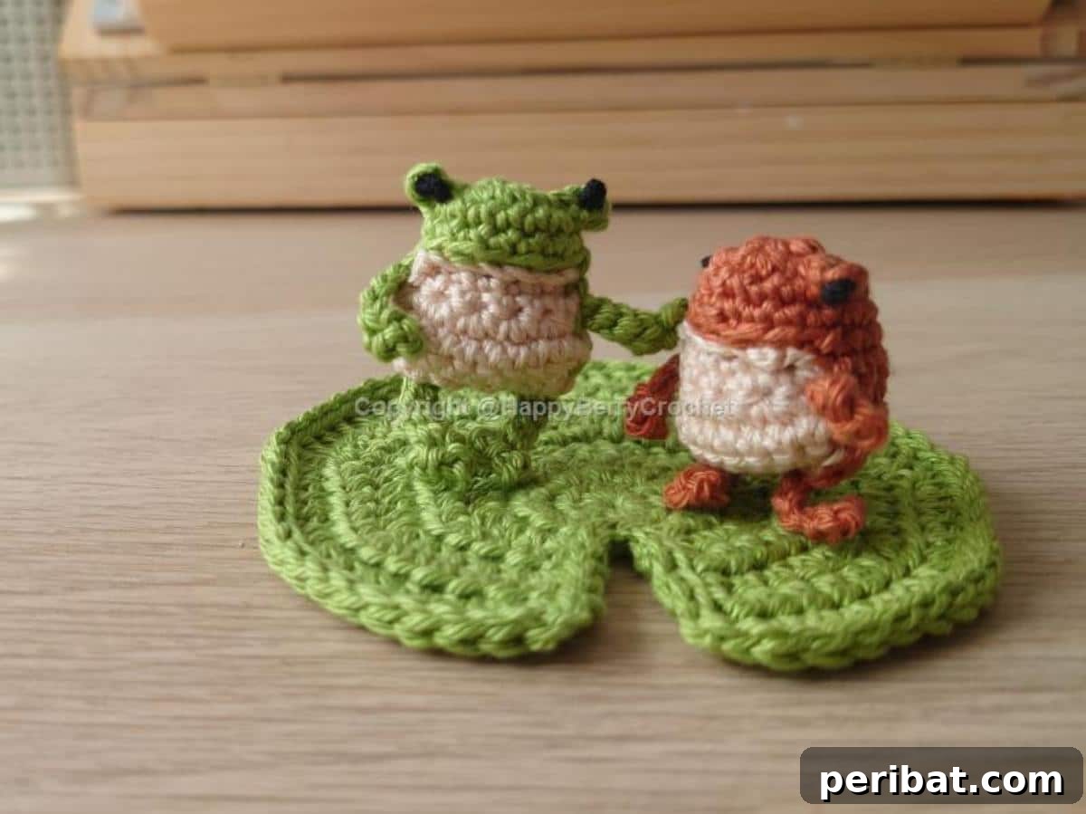 Two tiny and charming amigurumi crochet mini frogs, one green and one striped.
