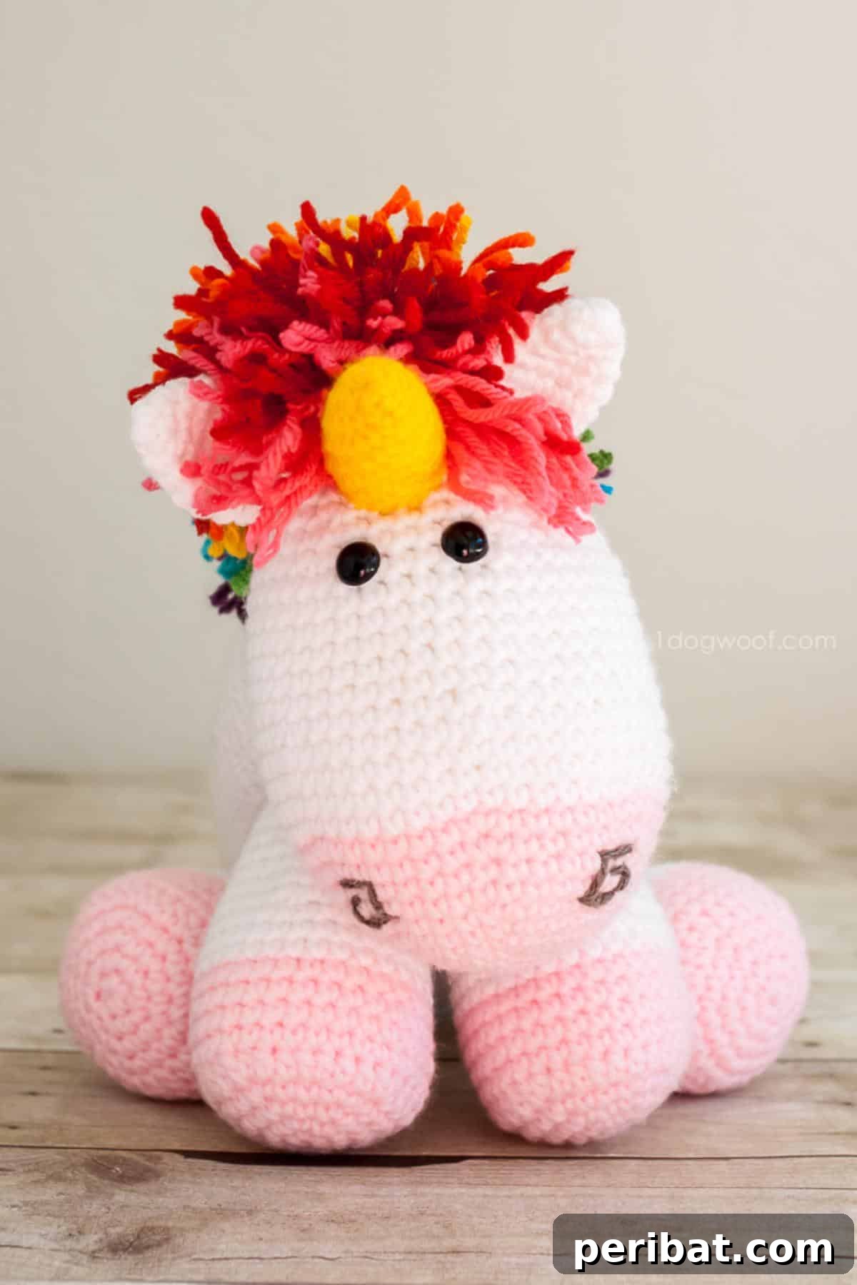 A whimsical amigurumi Rainbow Cuddles Crochet Unicorn with a colorful mane, tail, and horn.