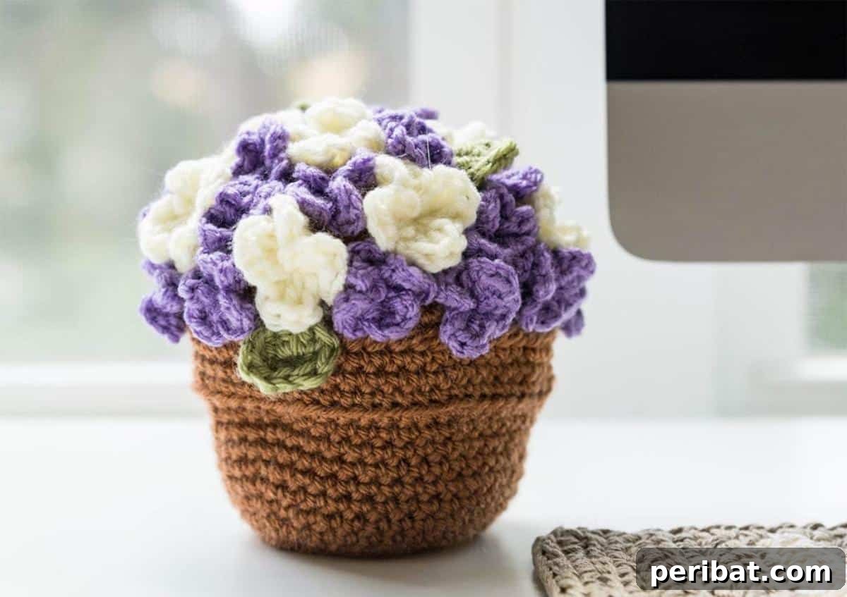 A charming crochet flower pot with delicate crocheted blooms, creating a complete handcrafted display.