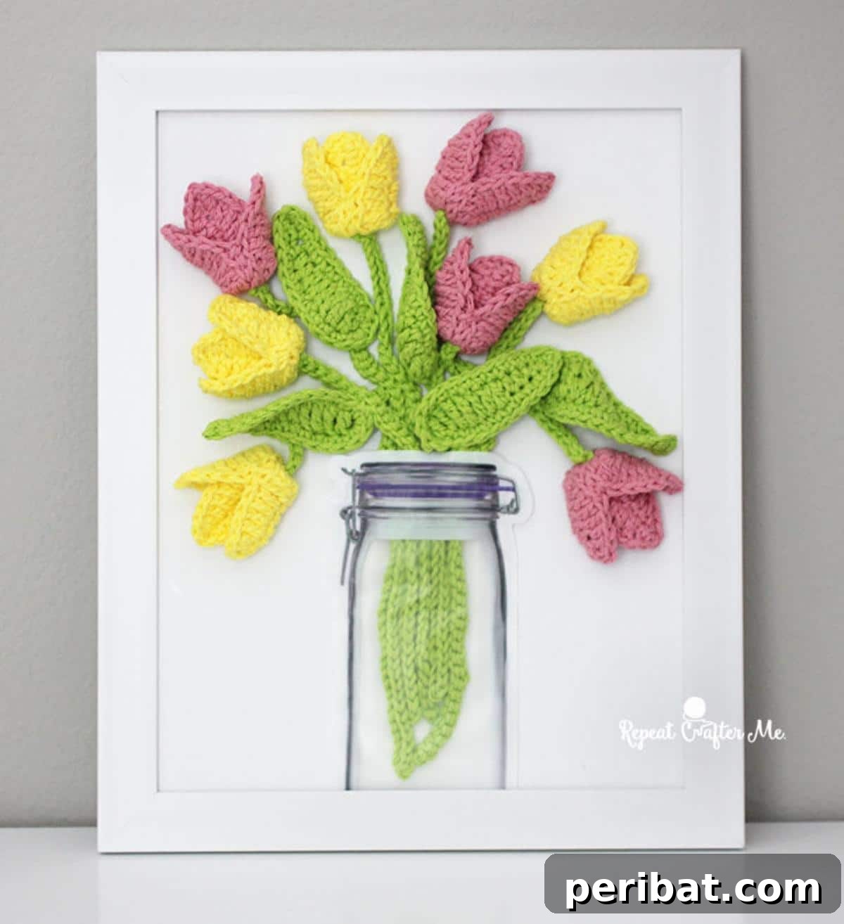 Artistic crochet tulips mounted on a canvas, blending fiber art with wall decor.