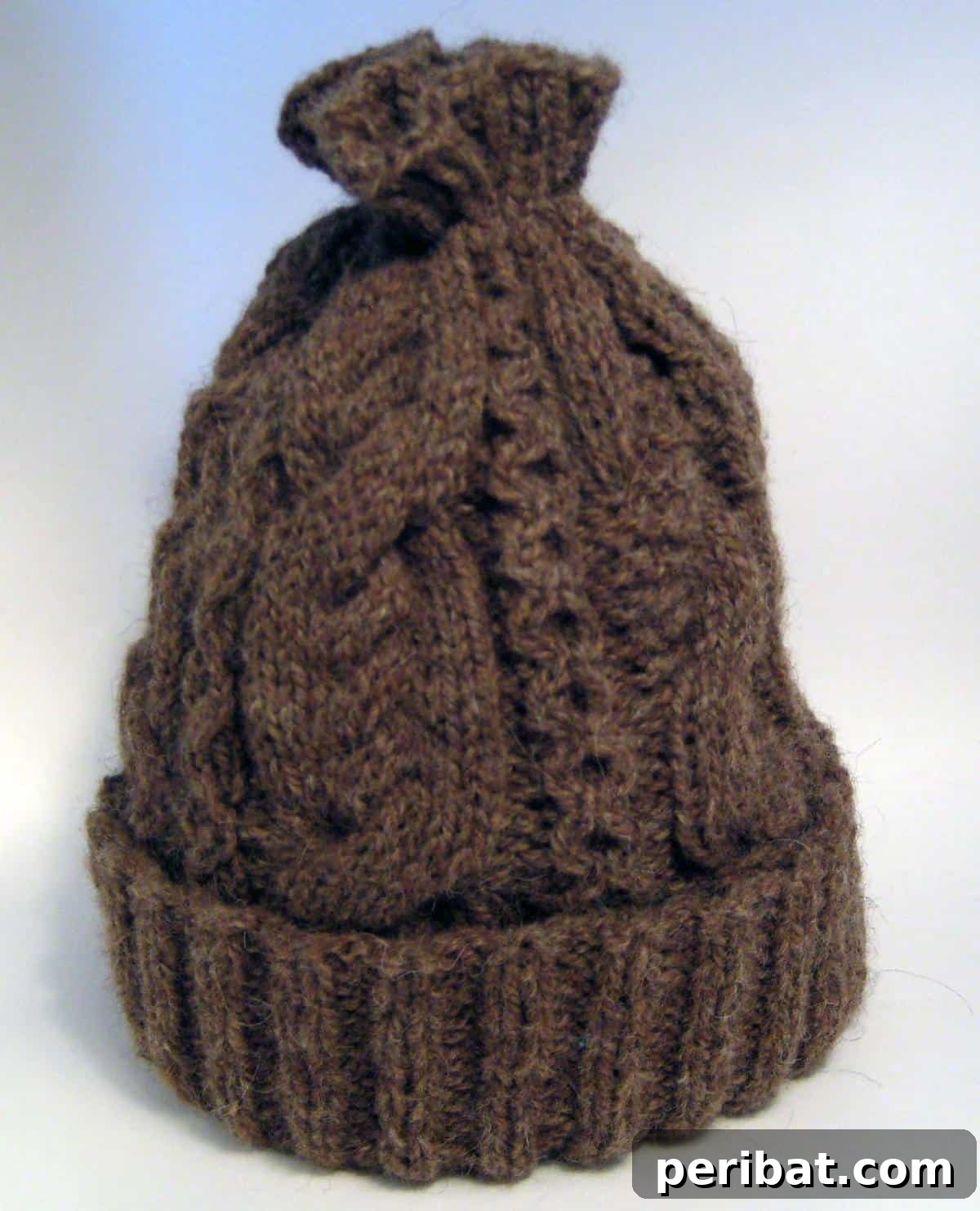 Cozy Knits: 40 Free Beanie Patterns and Tutorials 17 A beautifully intricate Cable Hat, featuring 14 unique cables around the crown and a ribbed brim for warmth, allowing for personalization with various yarn types.