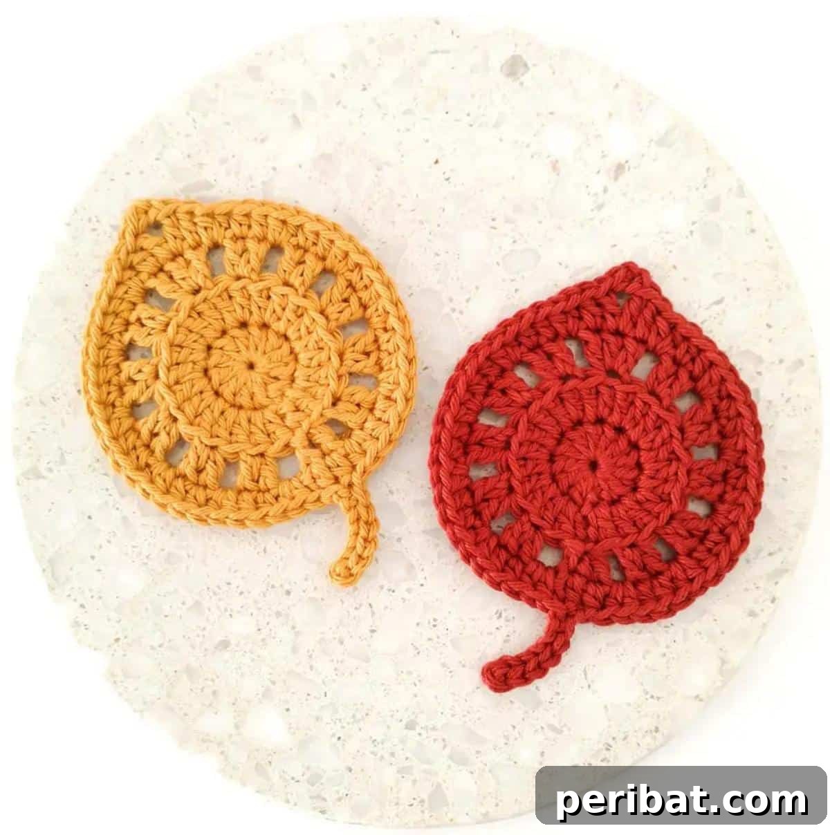 34 Inspiring Crochet Coaster Patterns 14 Beautiful fallen leaves crochet coasters in autumnal shades of orange, yellow, and brown, bringing fall charm indoors.
