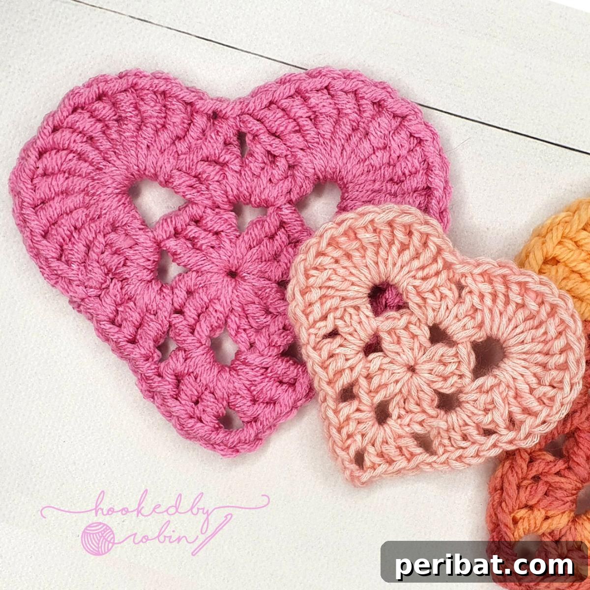 34 Inspiring Crochet Coaster Patterns 16 Charming crochet granny heart coasters in various pastel colors, showcasing a classic granny square technique with a romantic twist.