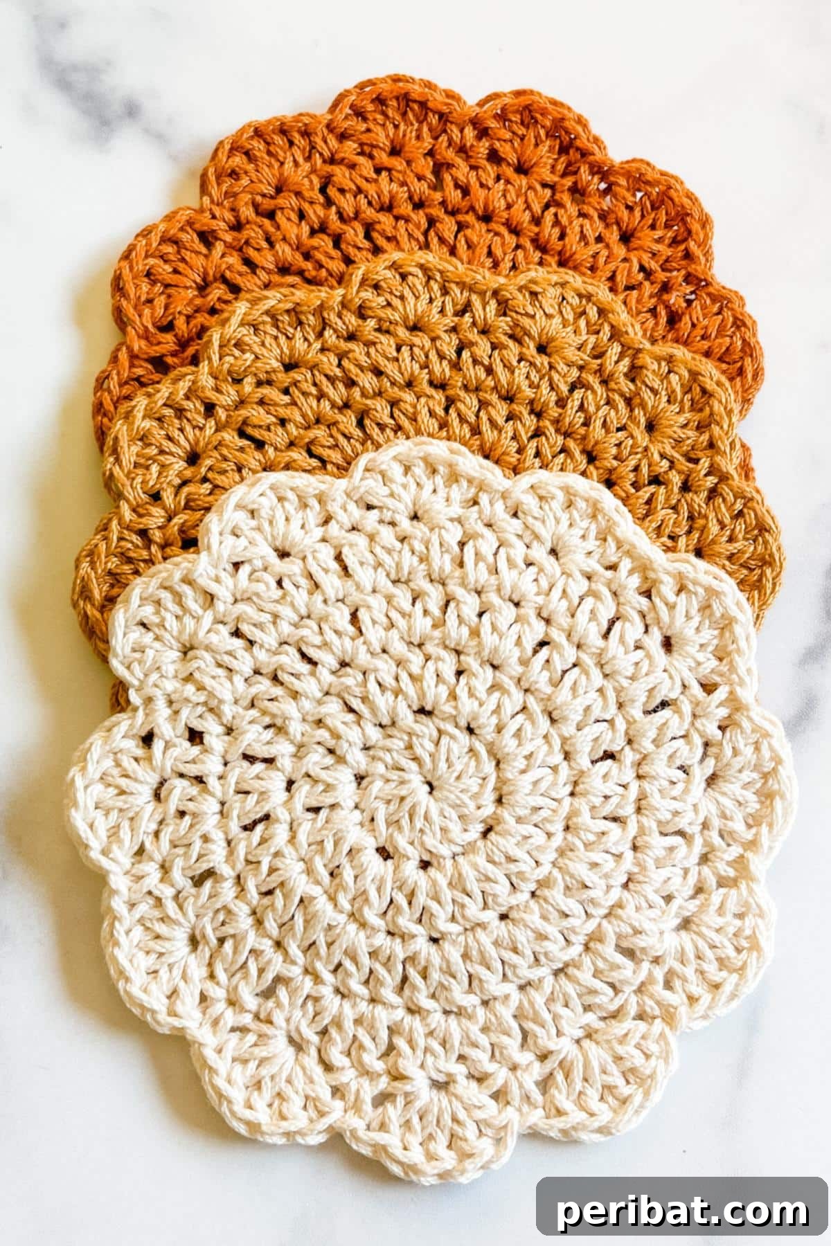 34 Inspiring Crochet Coaster Patterns 5 Colorful sunrise crochet coasters featuring concentric circles in warm, graduating colors, evoking a sunrise.