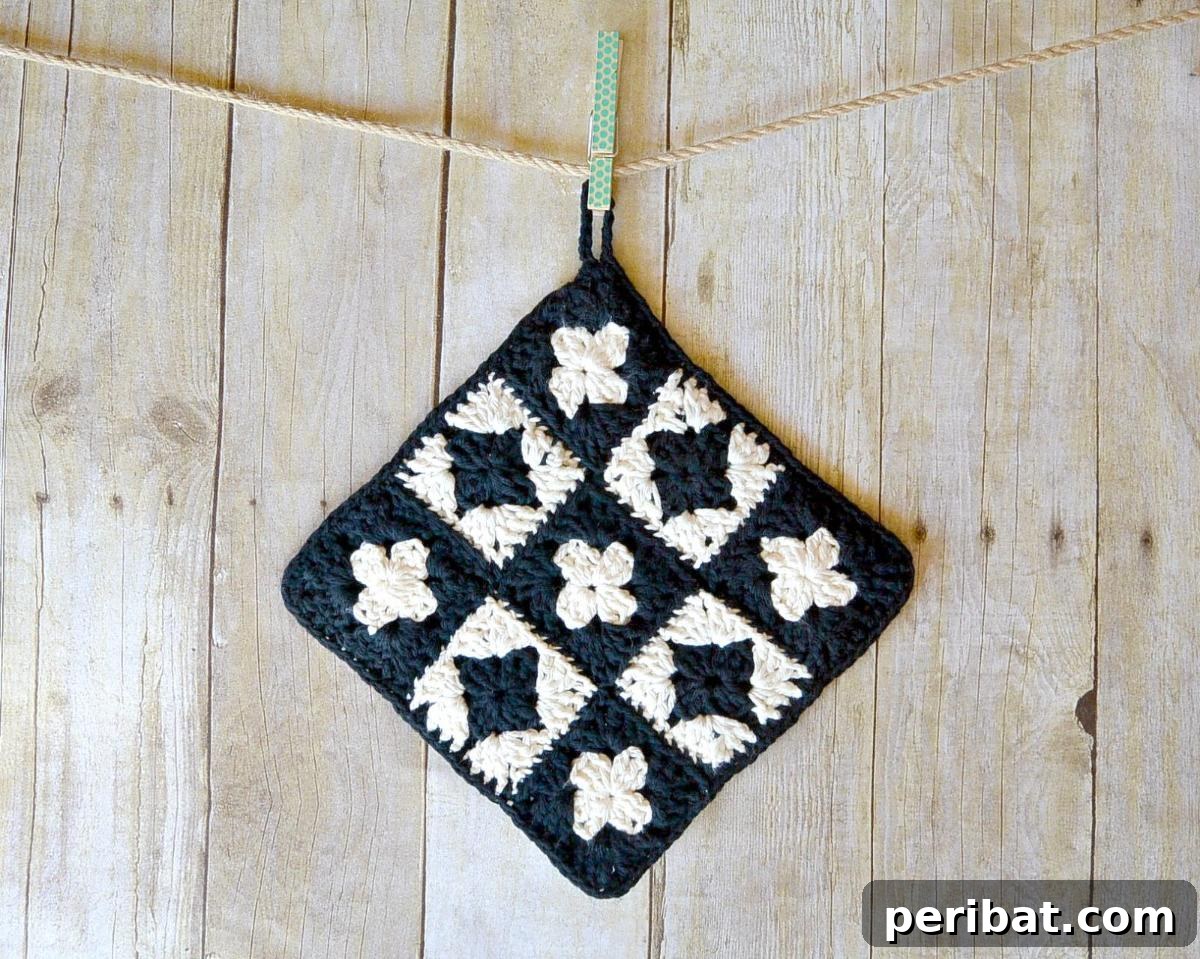 A chic modern granny square crochet potholder, featuring clean lines and a stylish color combination, redefining a classic motif.