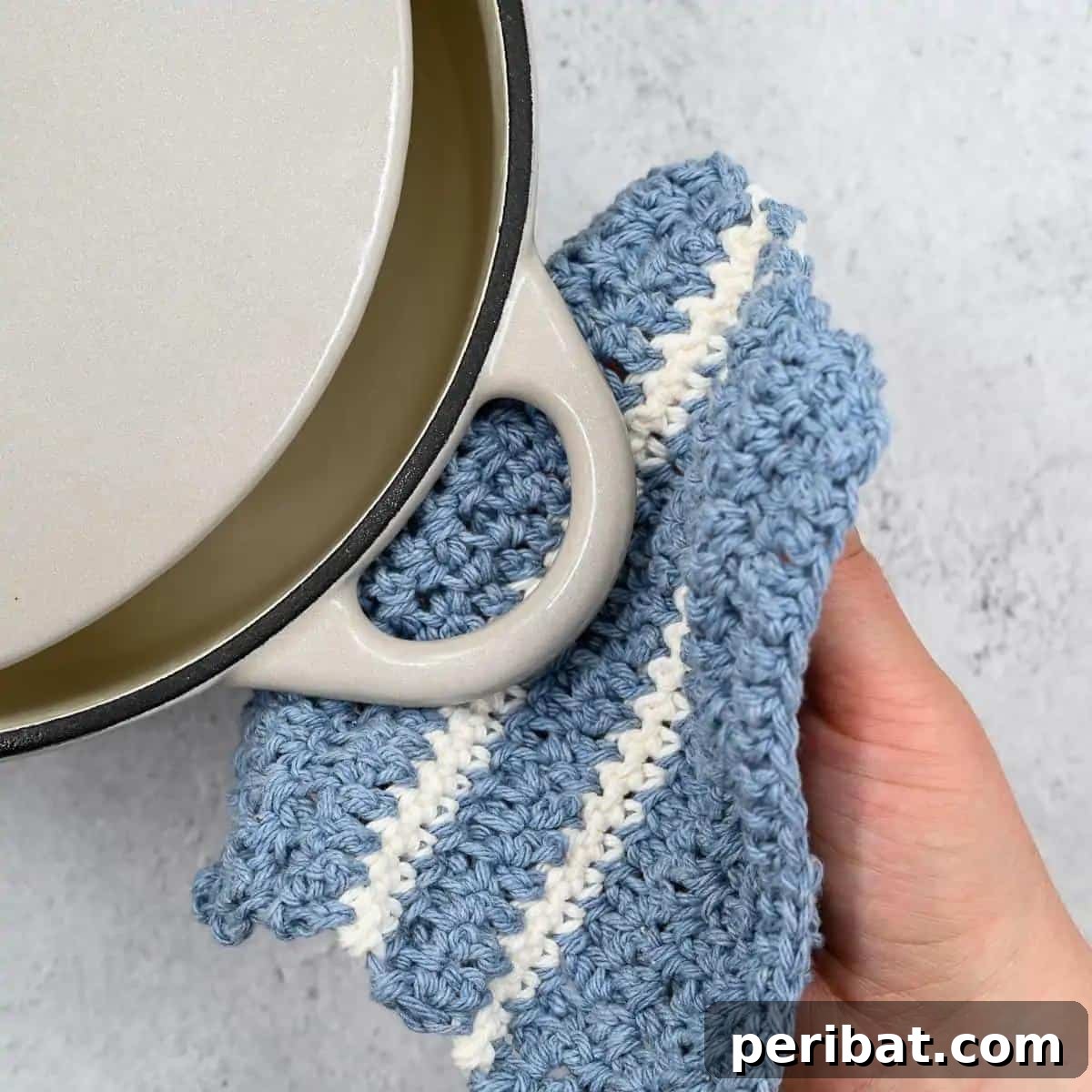 A textured DIY crochet potholder in a charming hexagonal shape, highlighting its dual utility as both a hot pad and washcloth.