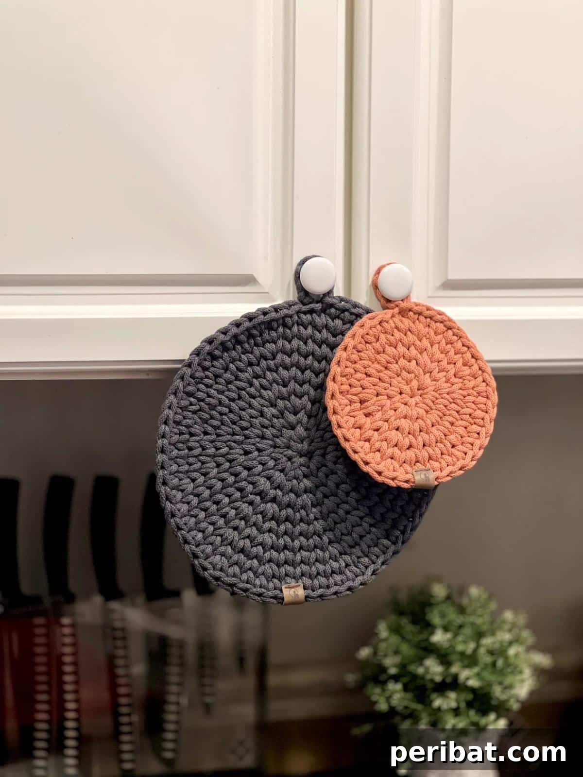 A practical set of hangable hot pads in three different sizes, showcasing integrated loops for convenient storage and accessibility.