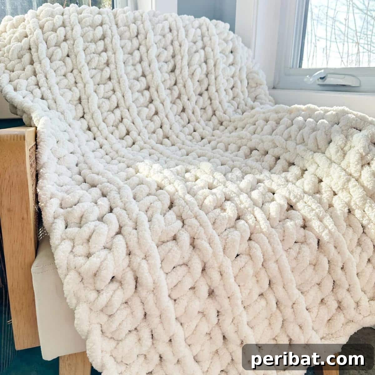 26 Quick & Cozy Chunky Crochet Projects 24 A luxurious Chunky Cabin Throw draped over a couch, highlighting its rich texture and inviting warmth, perfect for a cozy cabin aesthetic.