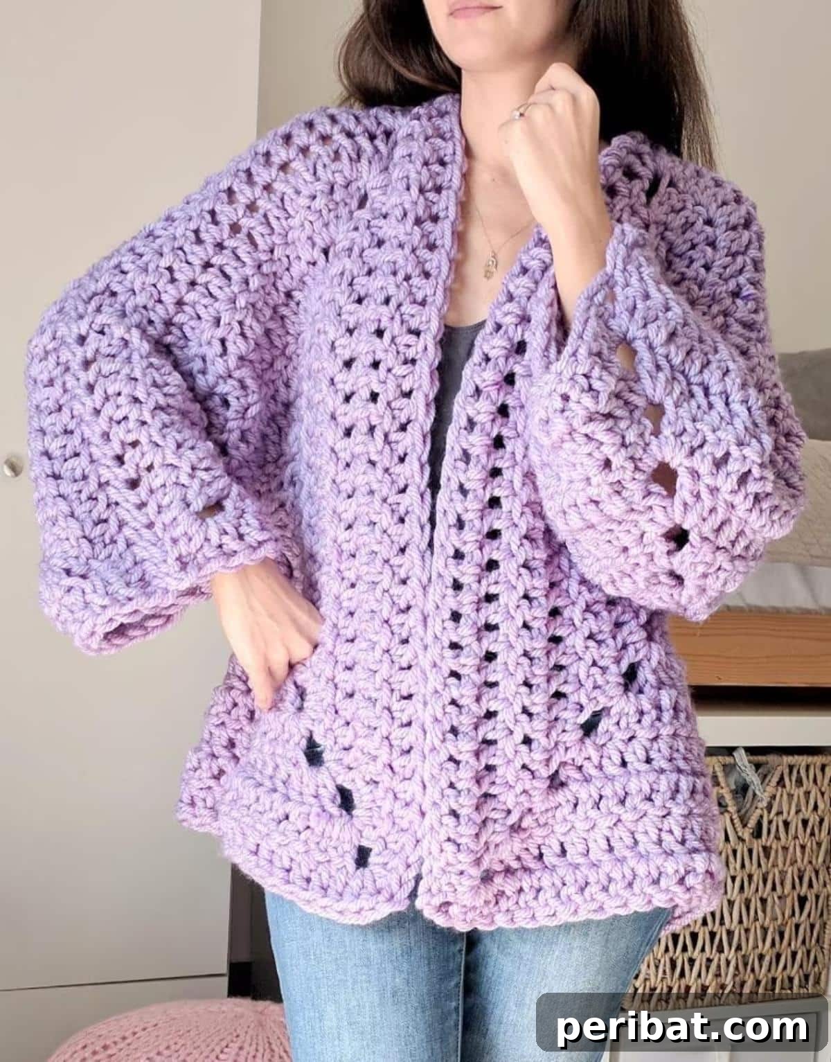 26 Quick & Cozy Chunky Crochet Projects 9 A model wearing a Super Chunky Hexagon Cardigan, demonstrating its oversized, comfortable fit and unique construction.