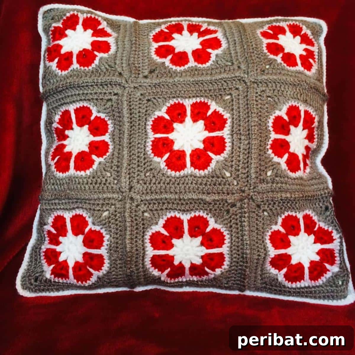 40 Creative Crochet Pillow Projects 12 A vibrant African Flower Pillow, intricately crocheted using colorful motifs that form a striking geometric pattern.