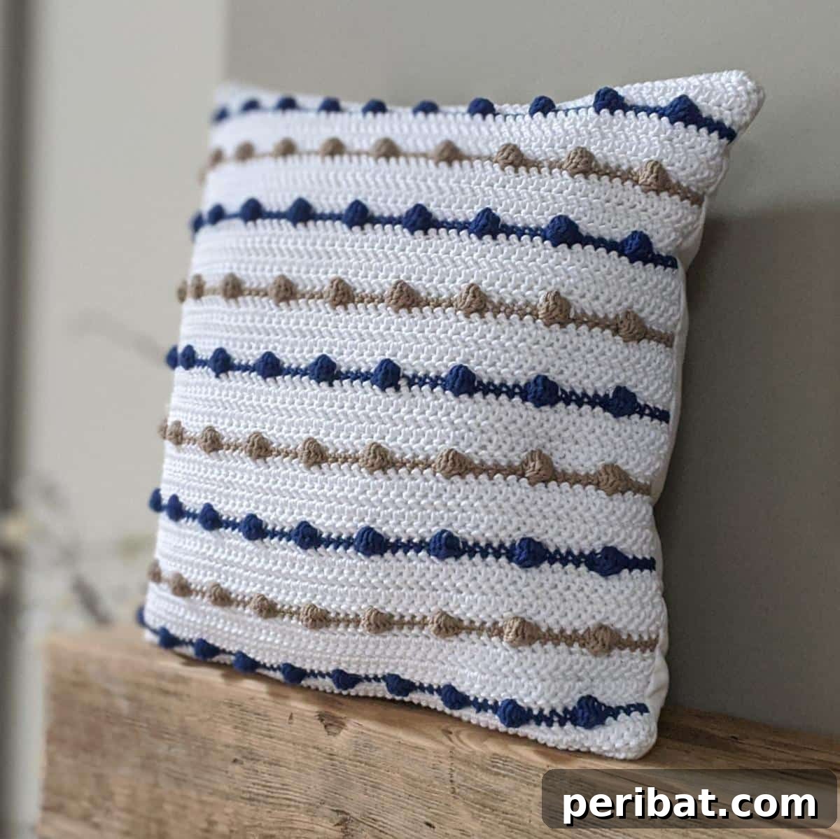40 Creative Crochet Pillow Projects 14 A rustic bobble stripe farmhouse pillow, featuring horizontal stripes of textured bobble stitches for a cozy, country-inspired look.