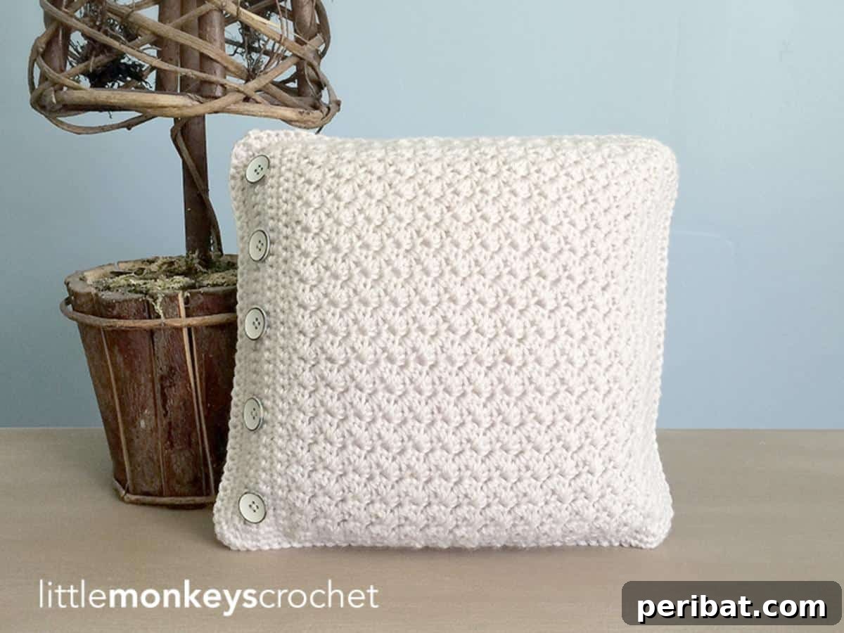 40 Creative Crochet Pillow Projects 18 A sophisticated buttoned throw pillow, featuring a textured crochet design and elegant functional buttons as a decorative element.