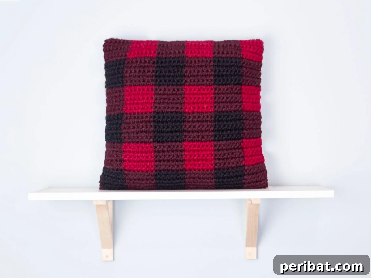 40 Creative Crochet Pillow Projects 19 A classic buffalo plaid crochet pillow, featuring the iconic black and red checkered pattern created with tapestry crochet.