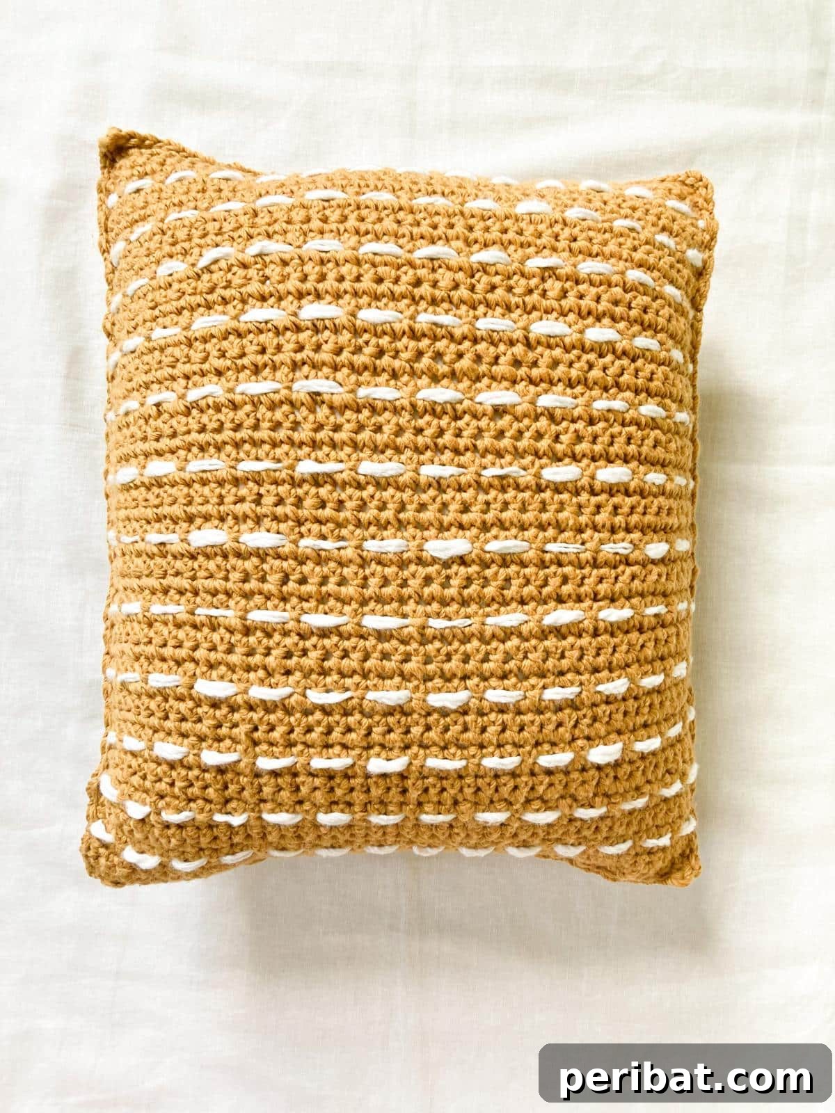 40 Creative Crochet Pillow Projects 20 A trendy striped boho crochet pillow, featuring earthy tones and textured stripes, with decorative tassels for a chic bohemian look.