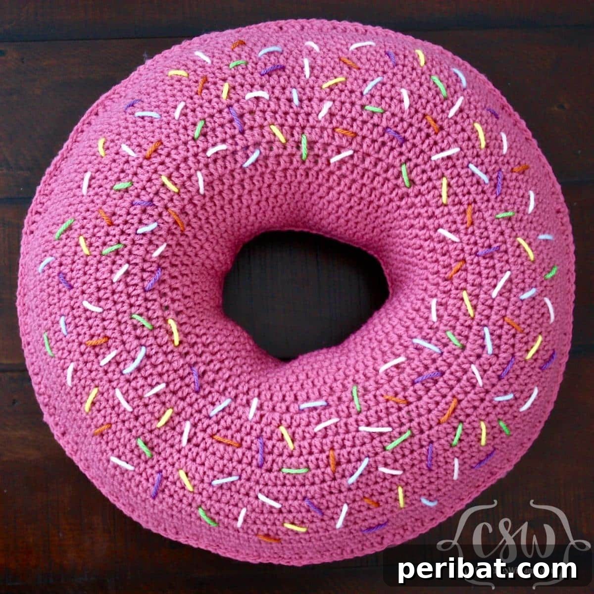 40 Creative Crochet Pillow Projects 3 A playful crochet donut pillow, featuring sprinkles and a cheerful, vibrant design, perfect for adding a whimsical touch to any room.