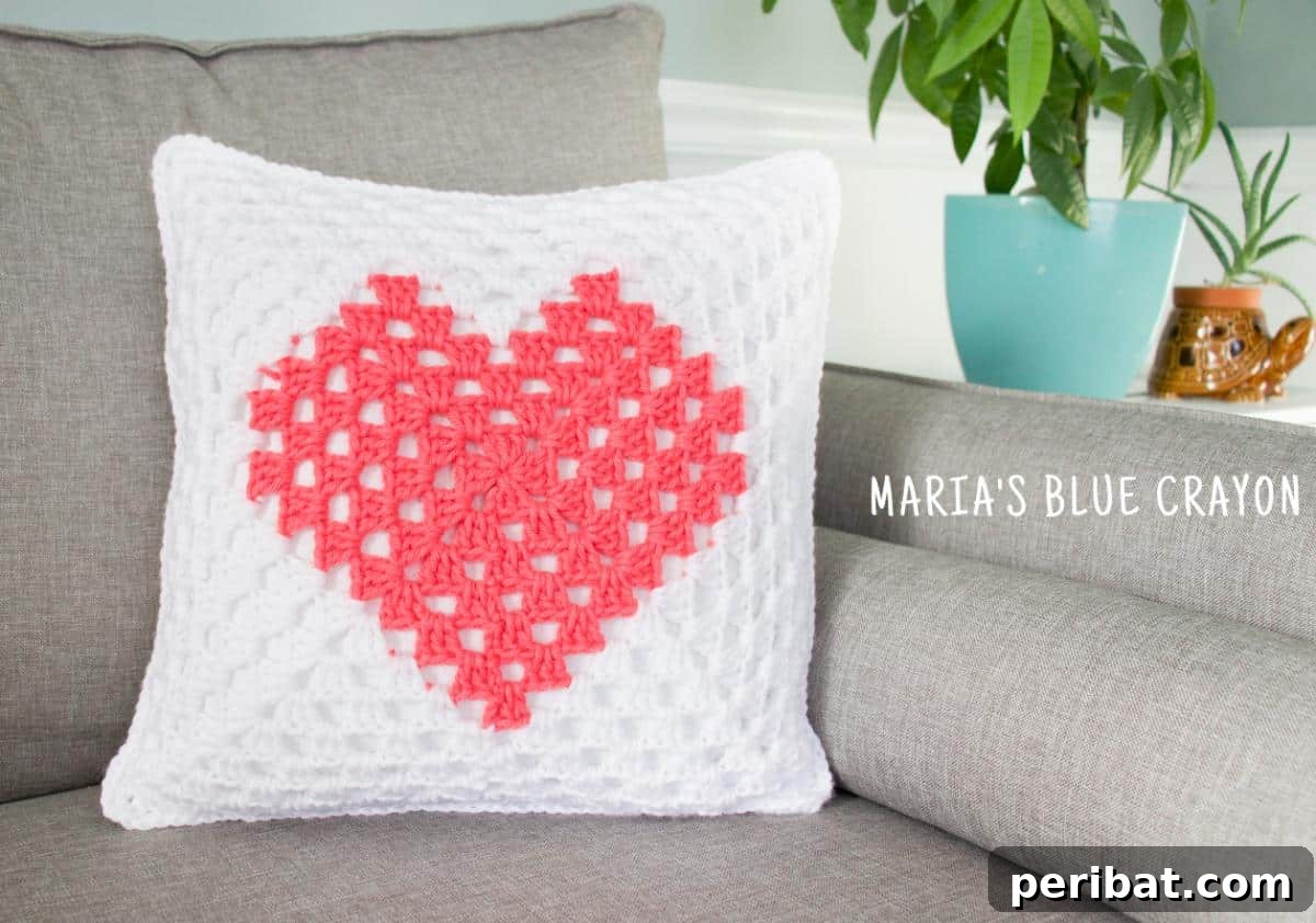 40 Creative Crochet Pillow Projects 28 A charming granny square heart pillow, transforming the classic crochet motif into a lovely heart shape, perfect for a cozy, handmade feel.