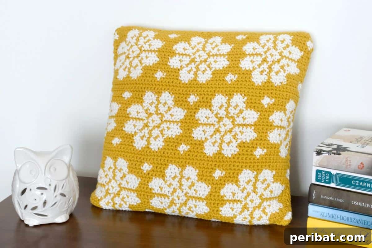 40 Creative Crochet Pillow Projects 4 An elegant dahlia flower crochet pillow cover, showcasing intricate intarsia crochet patterns in contrasting colors.