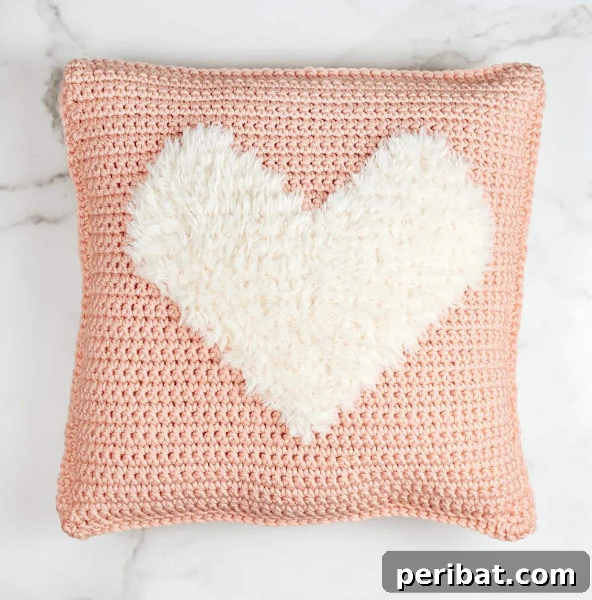 40 Creative Crochet Pillow Projects 34 A super bulky 'Love to Cuddle' crochet pillow, featuring a soft faux fur heart applique for an extra cozy and inviting feel.