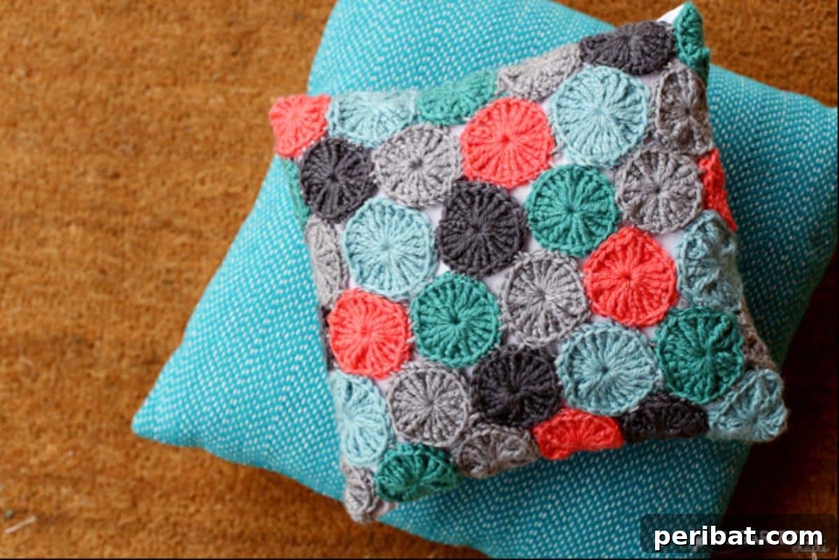 40 Creative Crochet Pillow Projects 37 A playful crocheted Yo-Yo Pillow, made with vibrant yarn circles assembled to create a textured, whimsical surface, perfect for a cheerful accent.