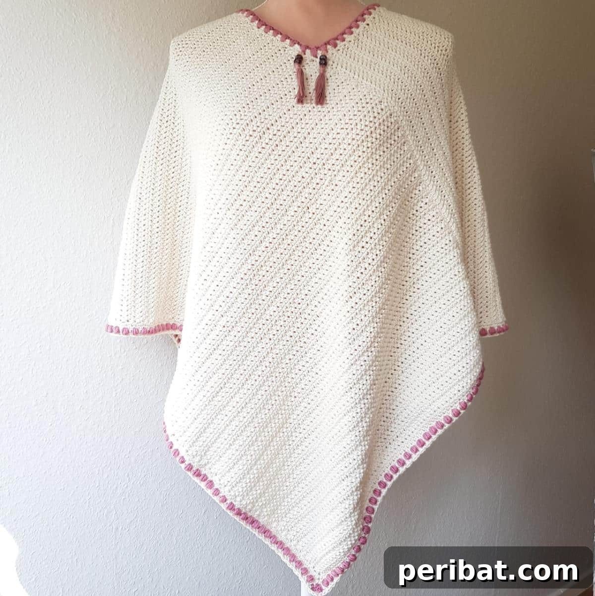 Topaz Poncho, a simple yet elegant crochet pattern featuring stylish tassels for an edgy and fashionable look.