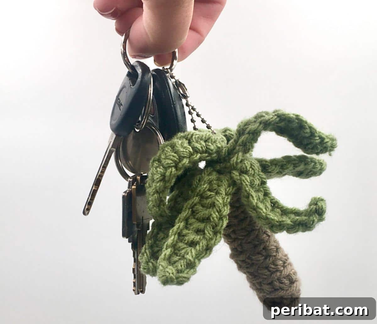 38 Adorable Crochet Keychain Patterns 20 Palm Tree Keychain with green fronds and a brown trunk.