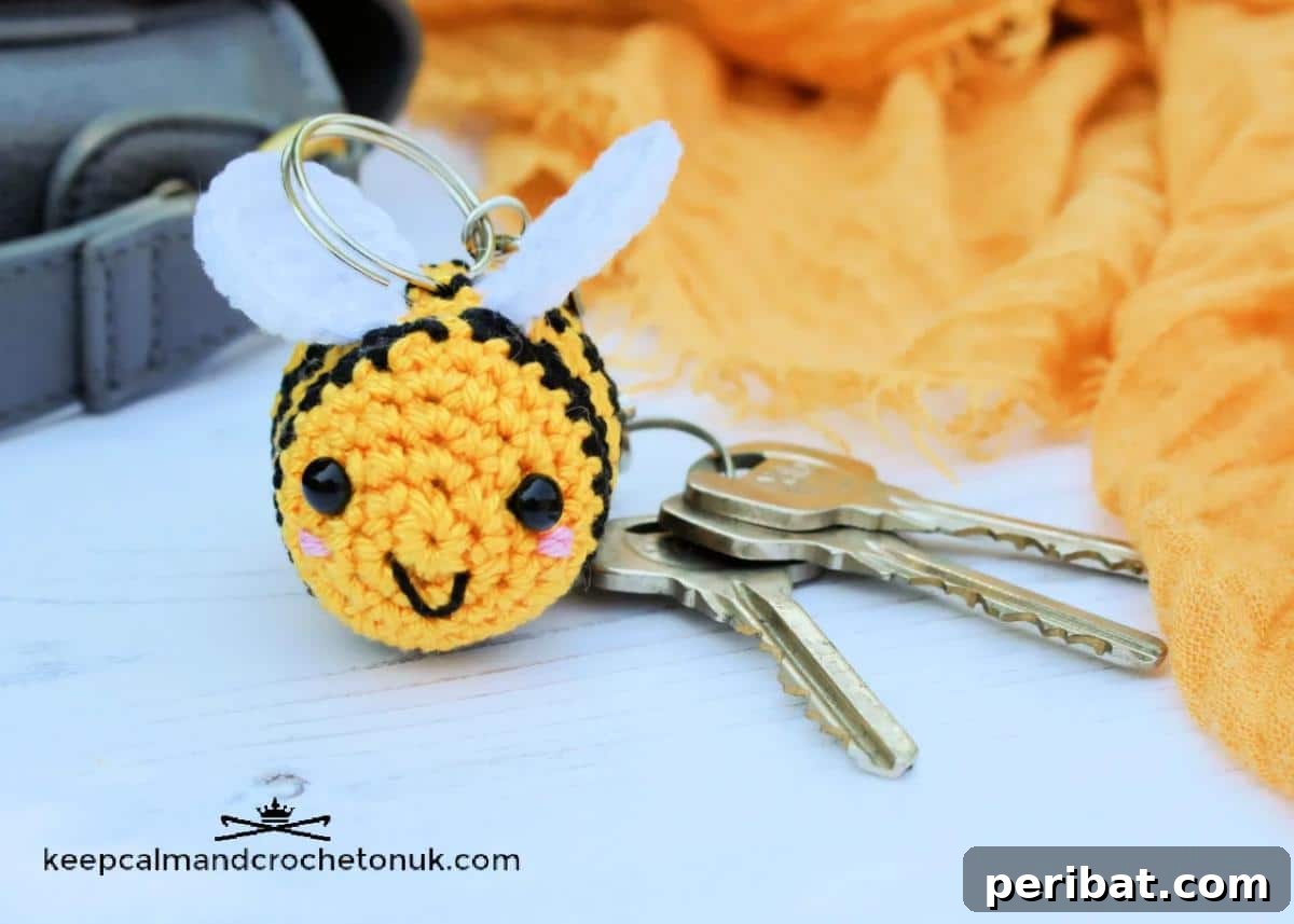 38 Adorable Crochet Keychain Patterns 33 Happy Bee Keyring, a cute yellow and black striped bee.