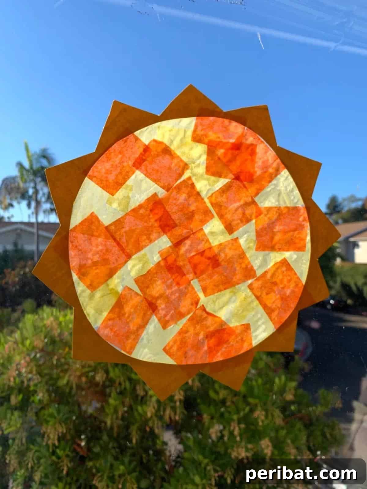 23 Vibrant DIY Tissue Paper Suncatcher Projects 11 A bright yellow sunshine-shaped tissue paper suncatcher, radiating warmth.