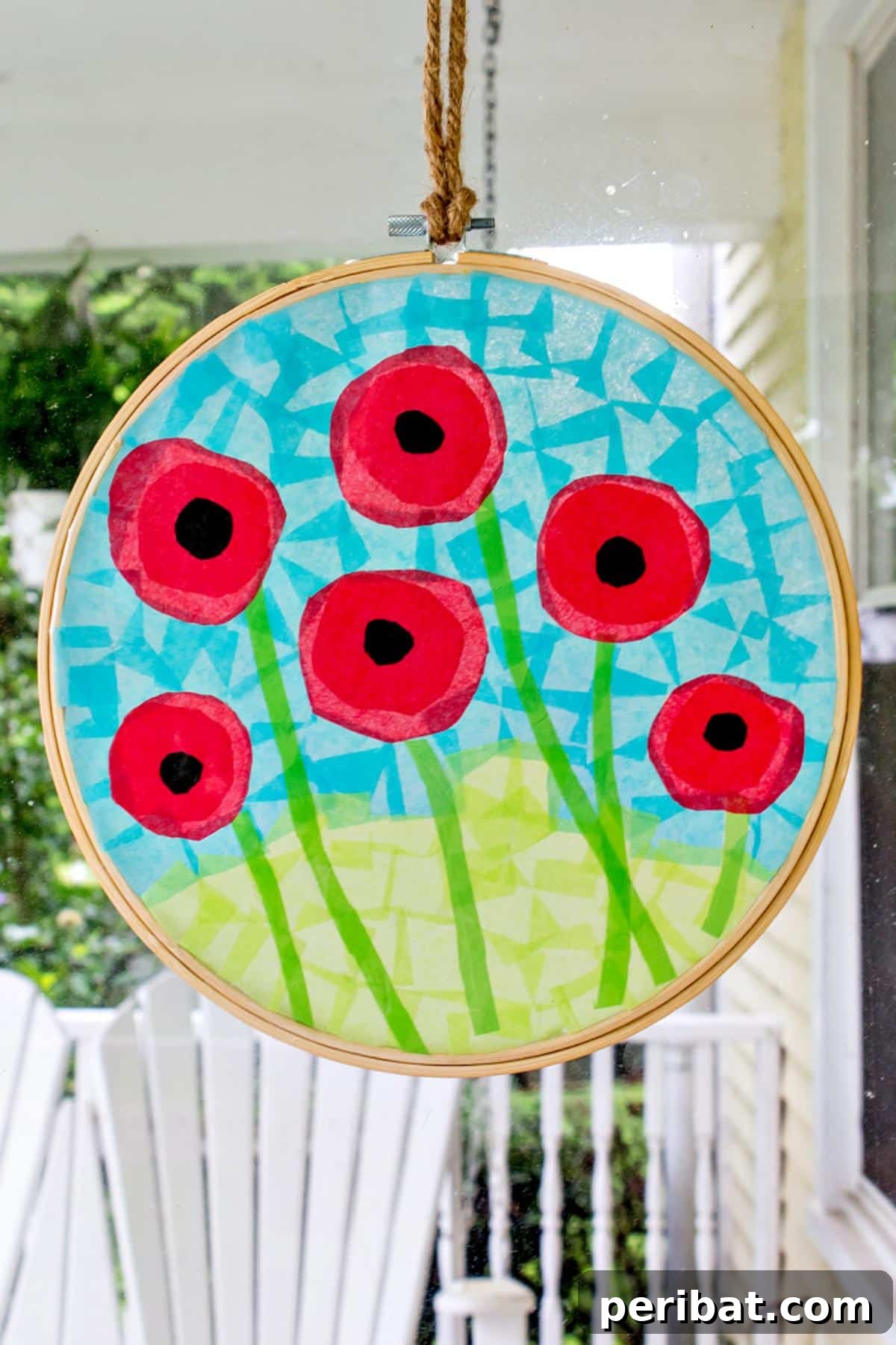 23 Vibrant DIY Tissue Paper Suncatcher Projects 12 A large, red poppy flower suncatcher made with tissue paper, showing intricate petal layers.