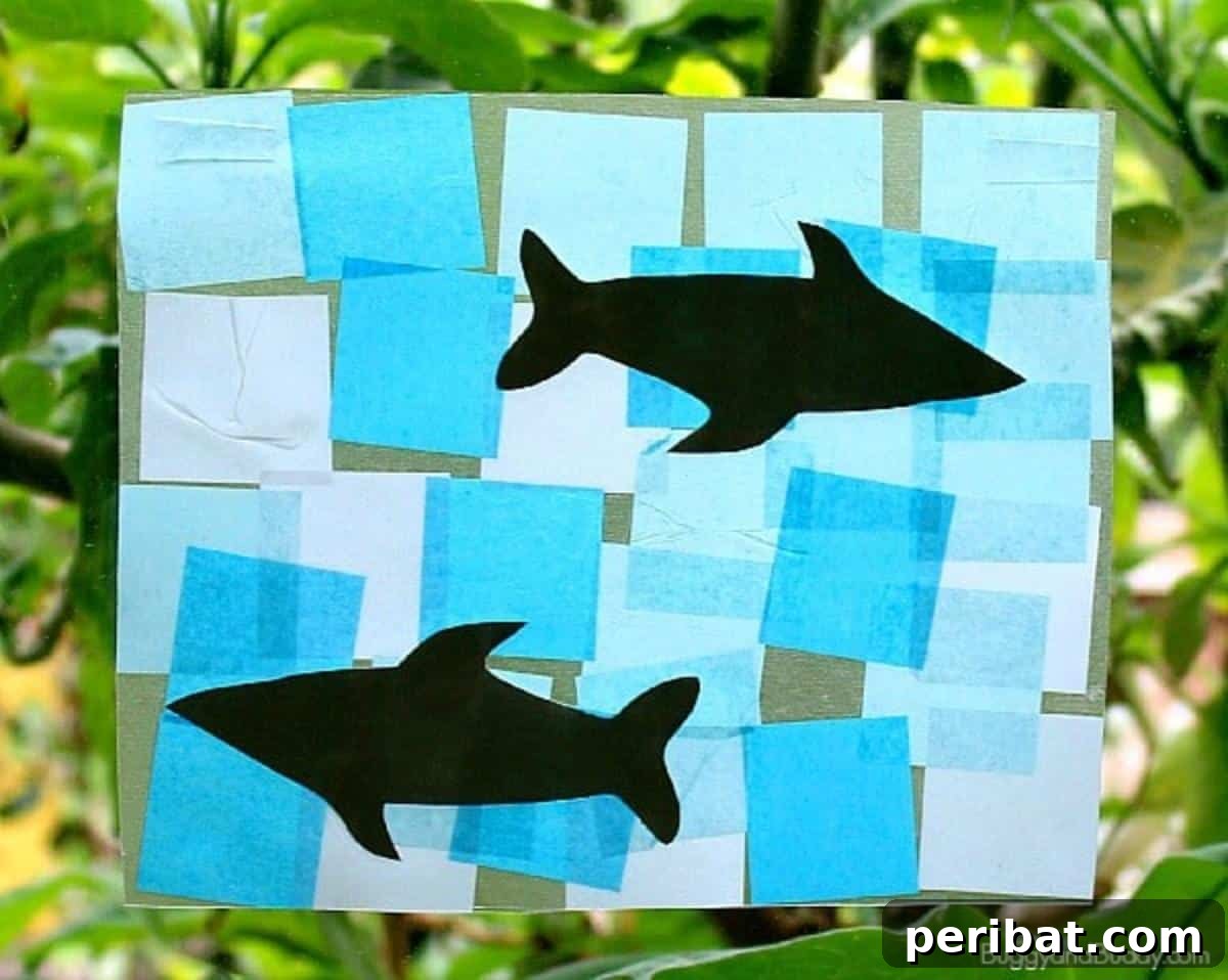 23 Vibrant DIY Tissue Paper Suncatcher Projects 15 A blue shark suncatcher with colorful tissue paper filling its body, perfect for preschool activities.