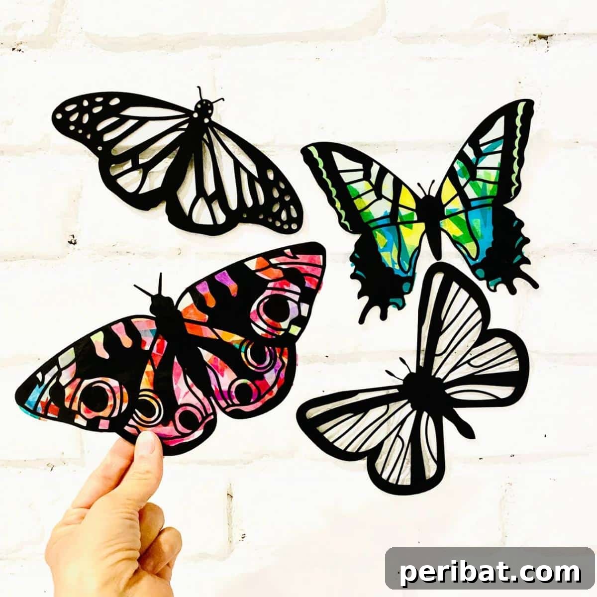 23 Vibrant DIY Tissue Paper Suncatcher Projects 25 A butterfly suncatcher papercraft kit with pre-cut black cardstock outlines and colorful tissue paper.