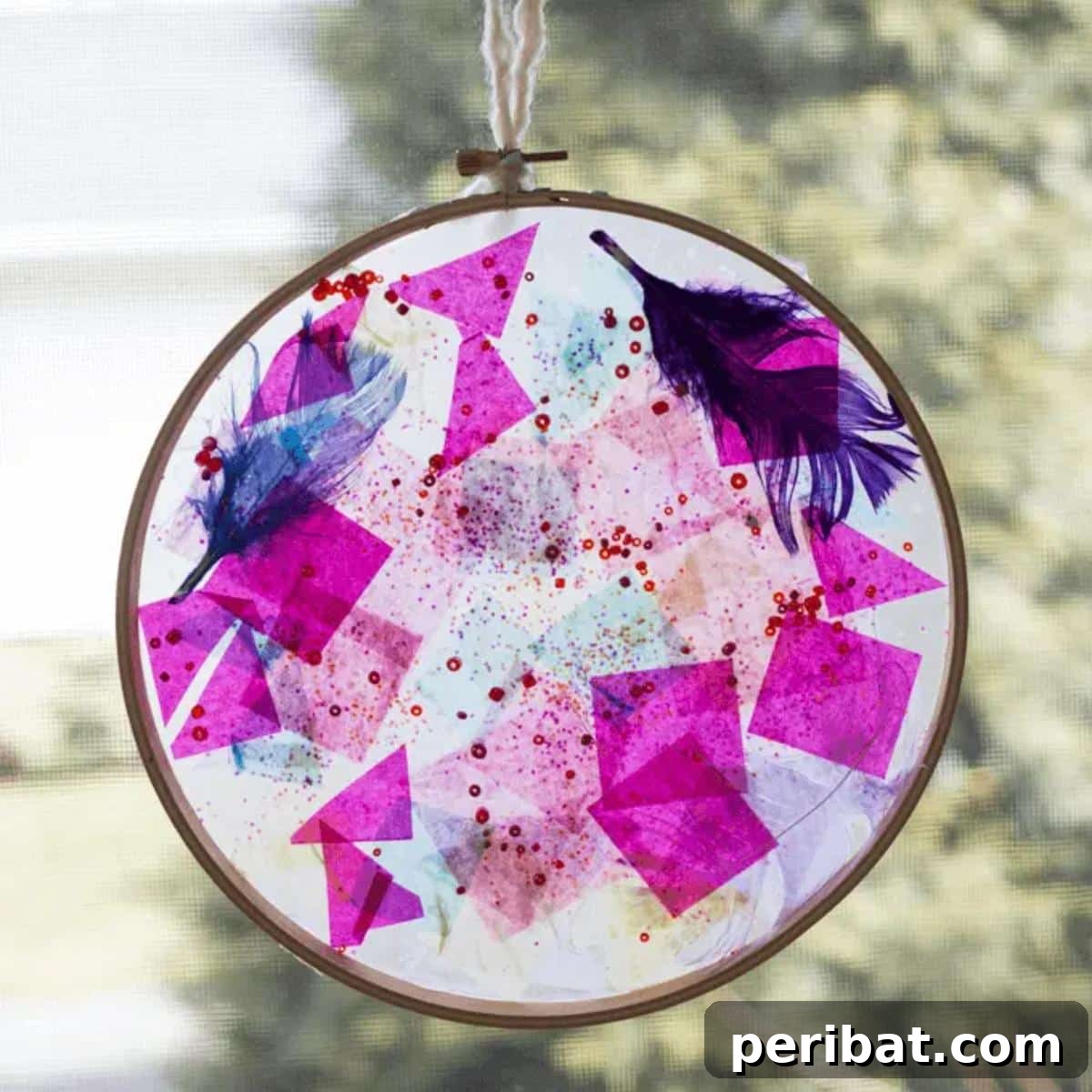 23 Vibrant DIY Tissue Paper Suncatcher Projects 7 A circular suncatcher framed in an embroidery hoop, filled with colorful tissue paper pieces.
