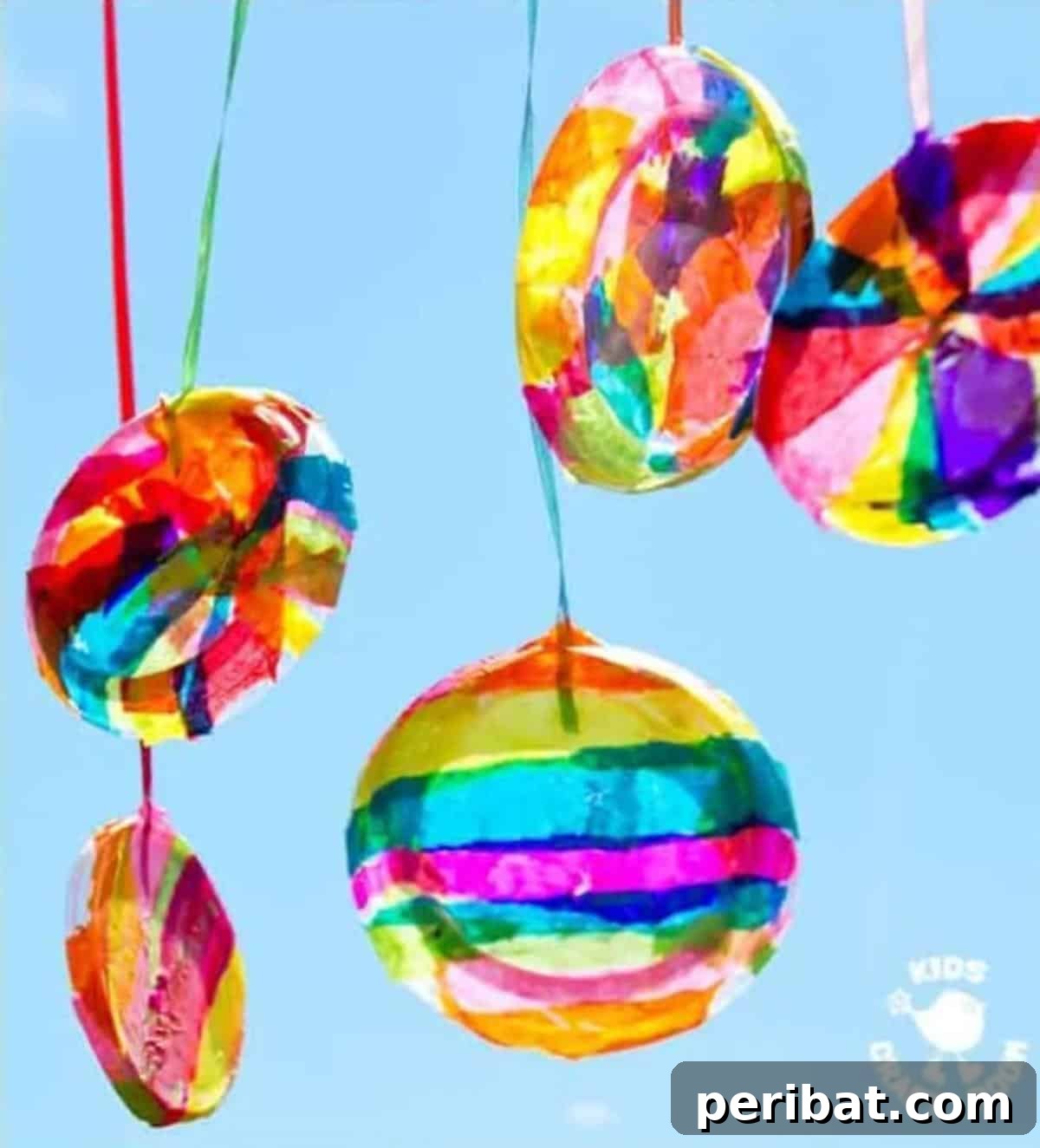 23 Vibrant DIY Tissue Paper Suncatcher Projects 8 A round suncatcher made with tissue paper and a plastic lid, hanging by a ribbon.