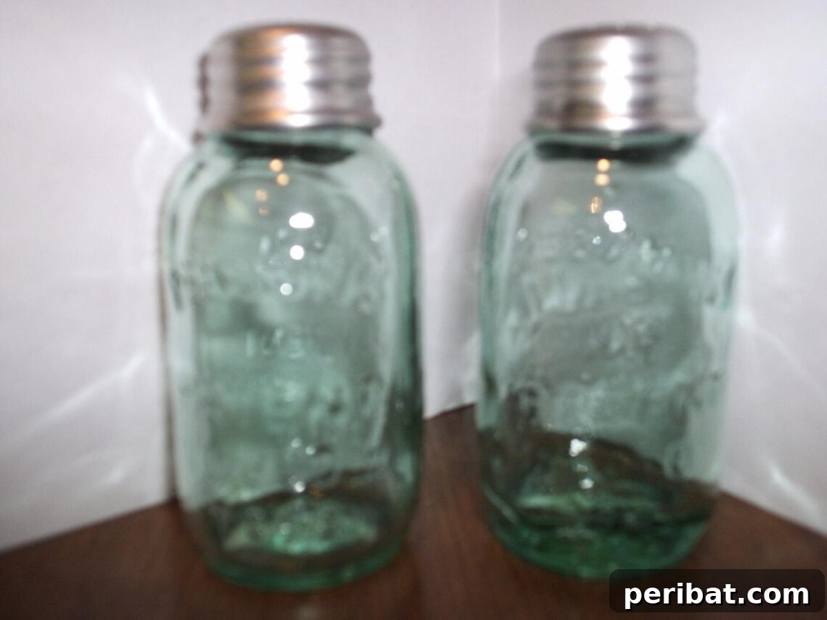 Crafting Colorful Salt Jars 25 Project Ideas 27 Classic Mason Jar Salt and Pepper Shakers, crafted from recycled glass, offering a rustic yet charming addition to any kitchen or dining table setting.