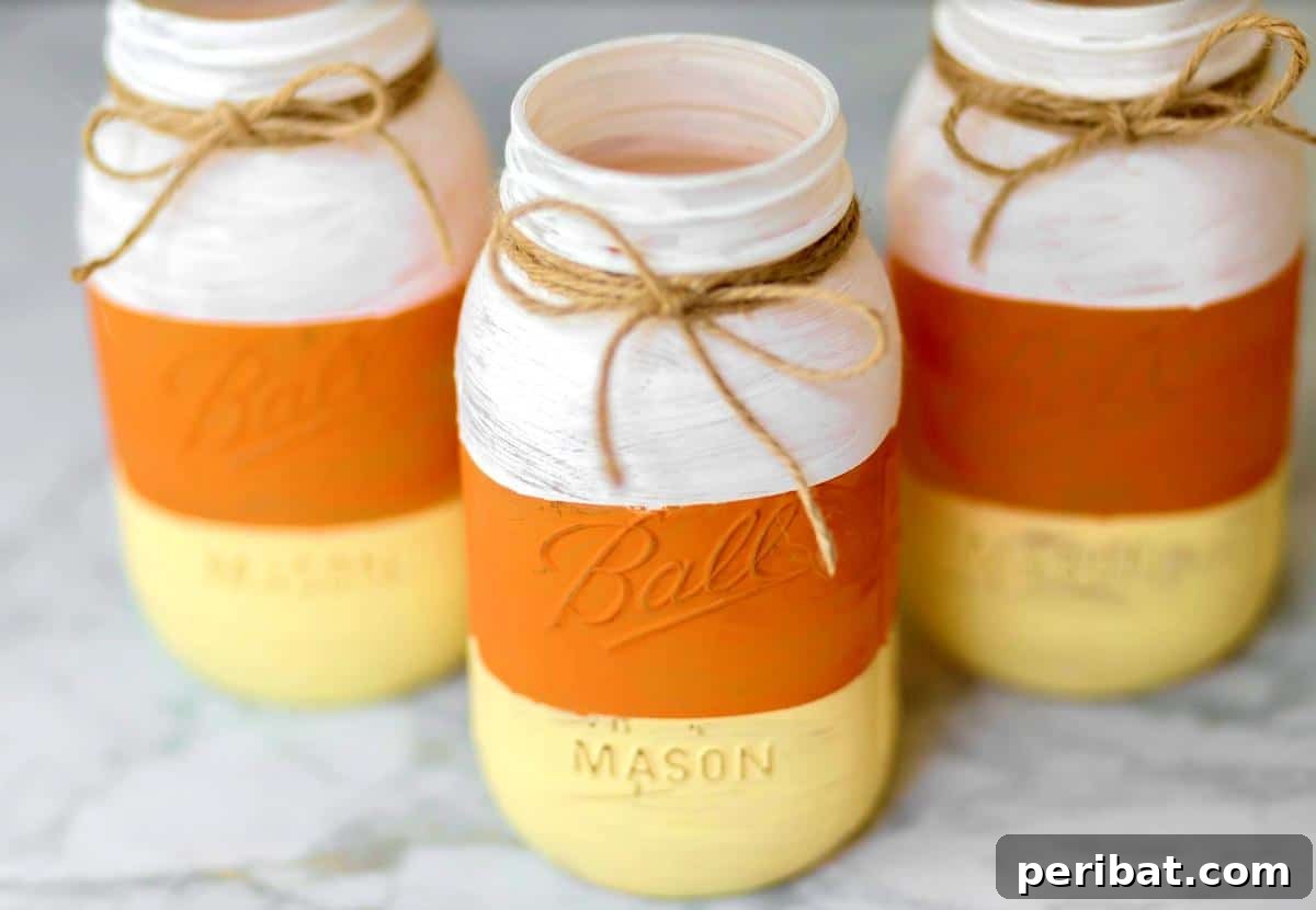 Vibrant DIY painted candy corn mason jars, adding a cheerful splash of fall color.