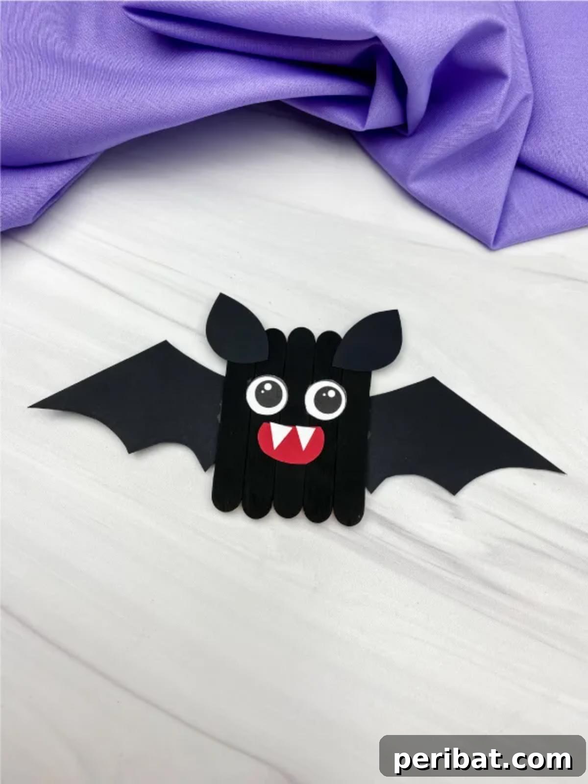 Spooktacular Popsicle Stick Halloween Projects 18 An adorable bat craft made from black-painted popsicle sticks with paper wings and googly eyes, designed for kids.