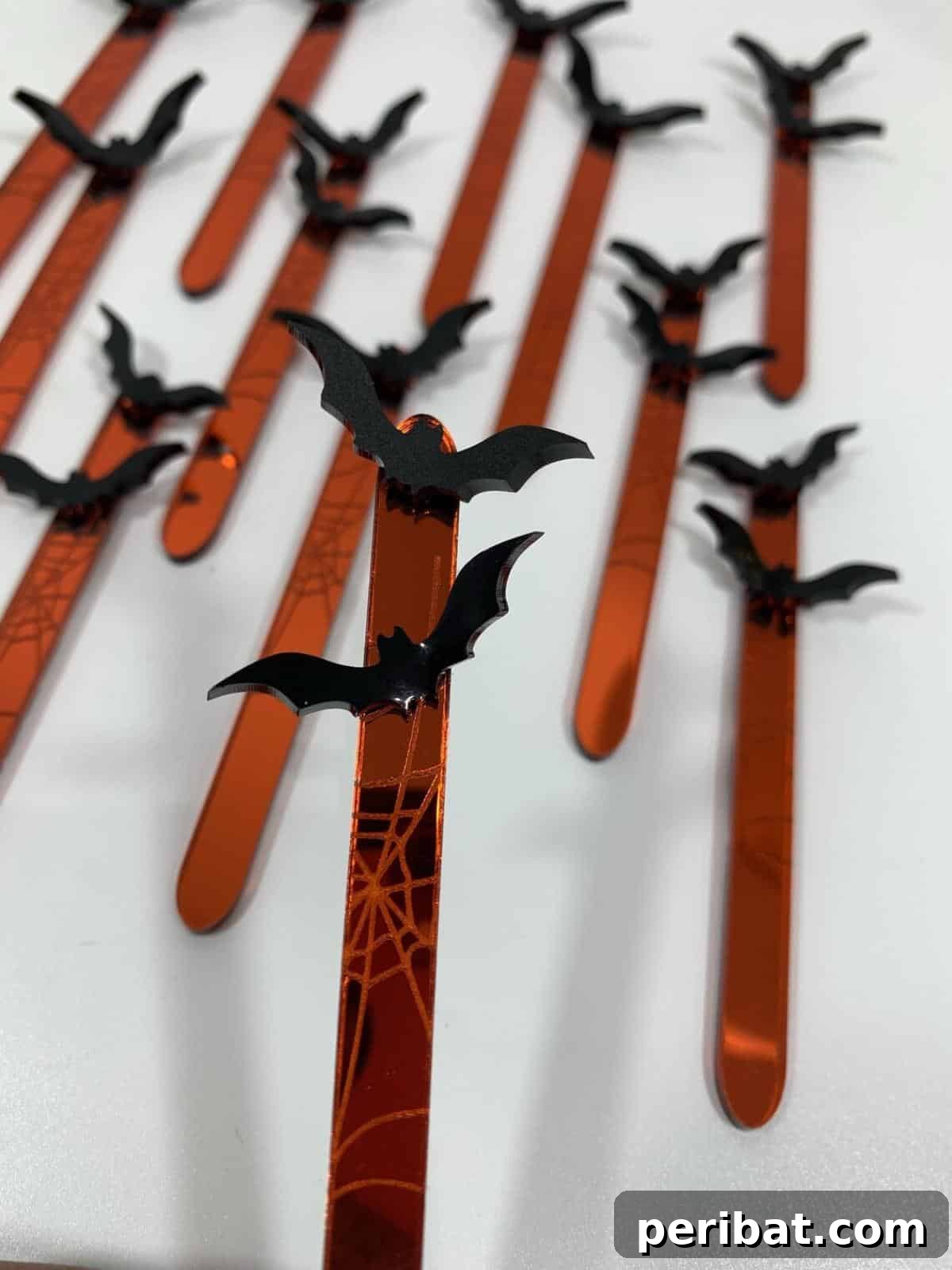 Spooktacular Popsicle Stick Halloween Projects 30 A collection of Halloween-themed cakesickle sticks, with vibrant orange, black, and purple designs, perfect for festive treats.