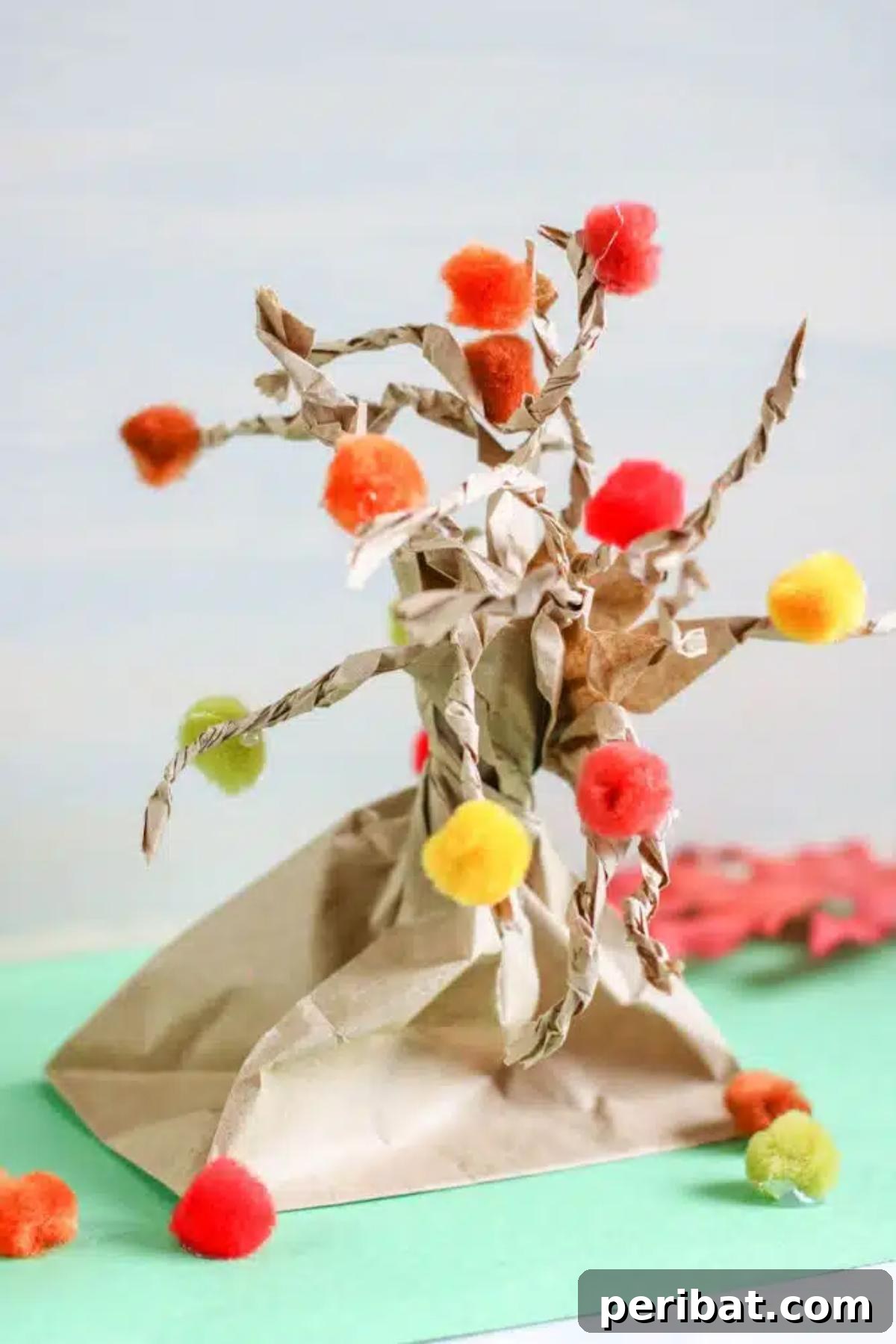 26 Autumnal Paper Bag Crafting Gems 14 A whimsical autumn tree craft made from a paper bag, adorned with colorful leaves.
