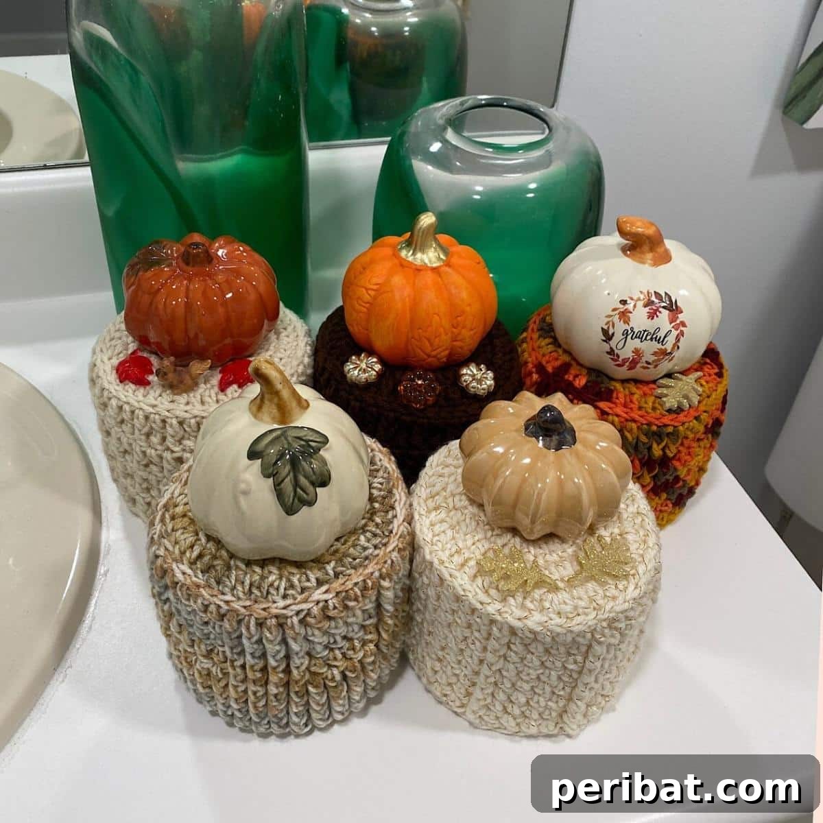 Pumpkin Toilet Paper Roll Cover, crocheted in orange with a green stem.