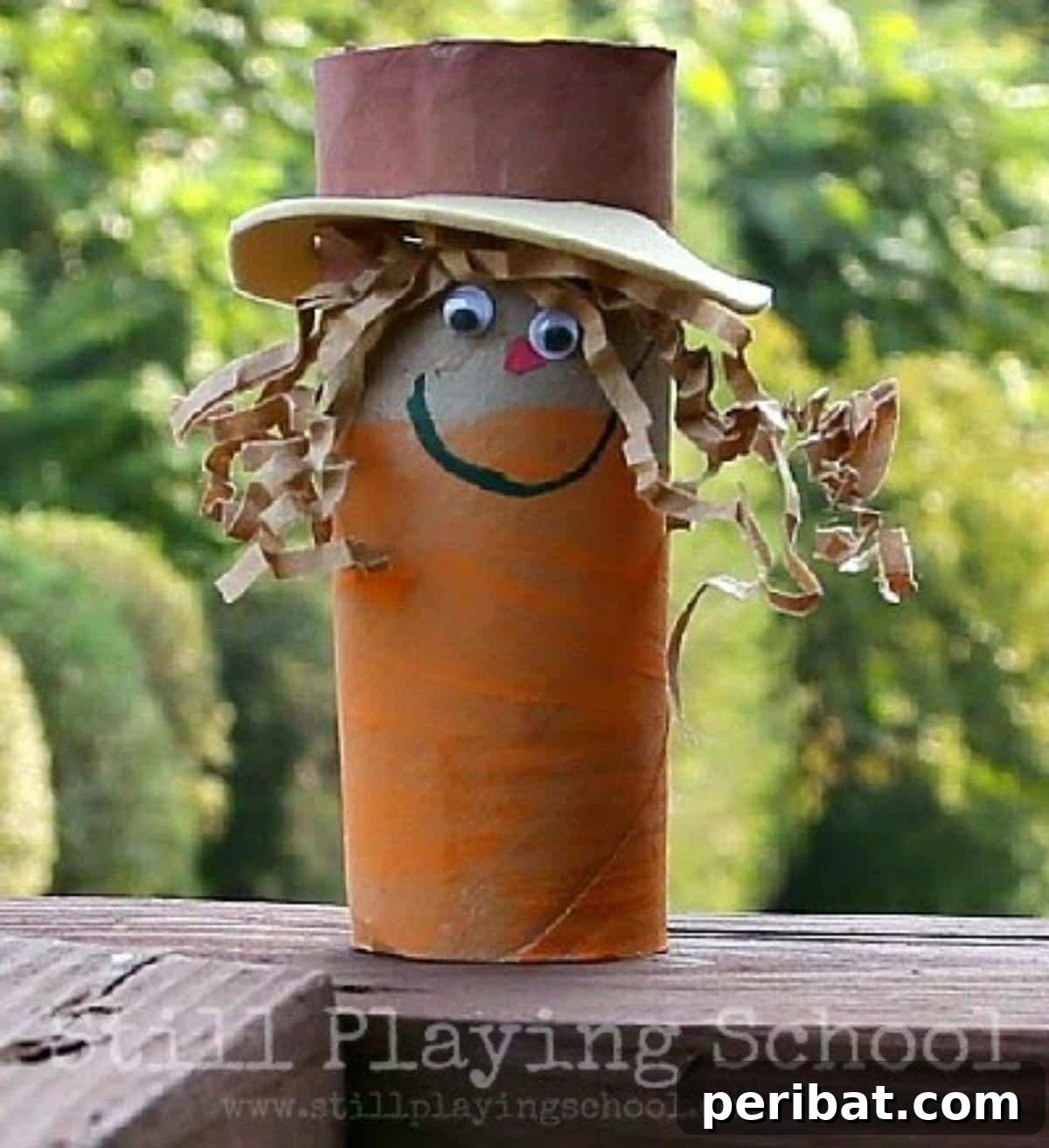 Toilet Paper Roll Scarecrow craft, decorated with straw and fabric scraps.